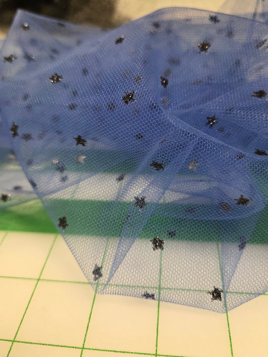 Blue sheer fabric with black embellishments on a grid background