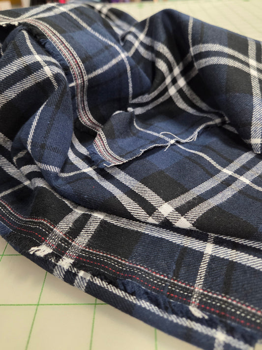 Plaid fabric on a cutting mat with a blurred background