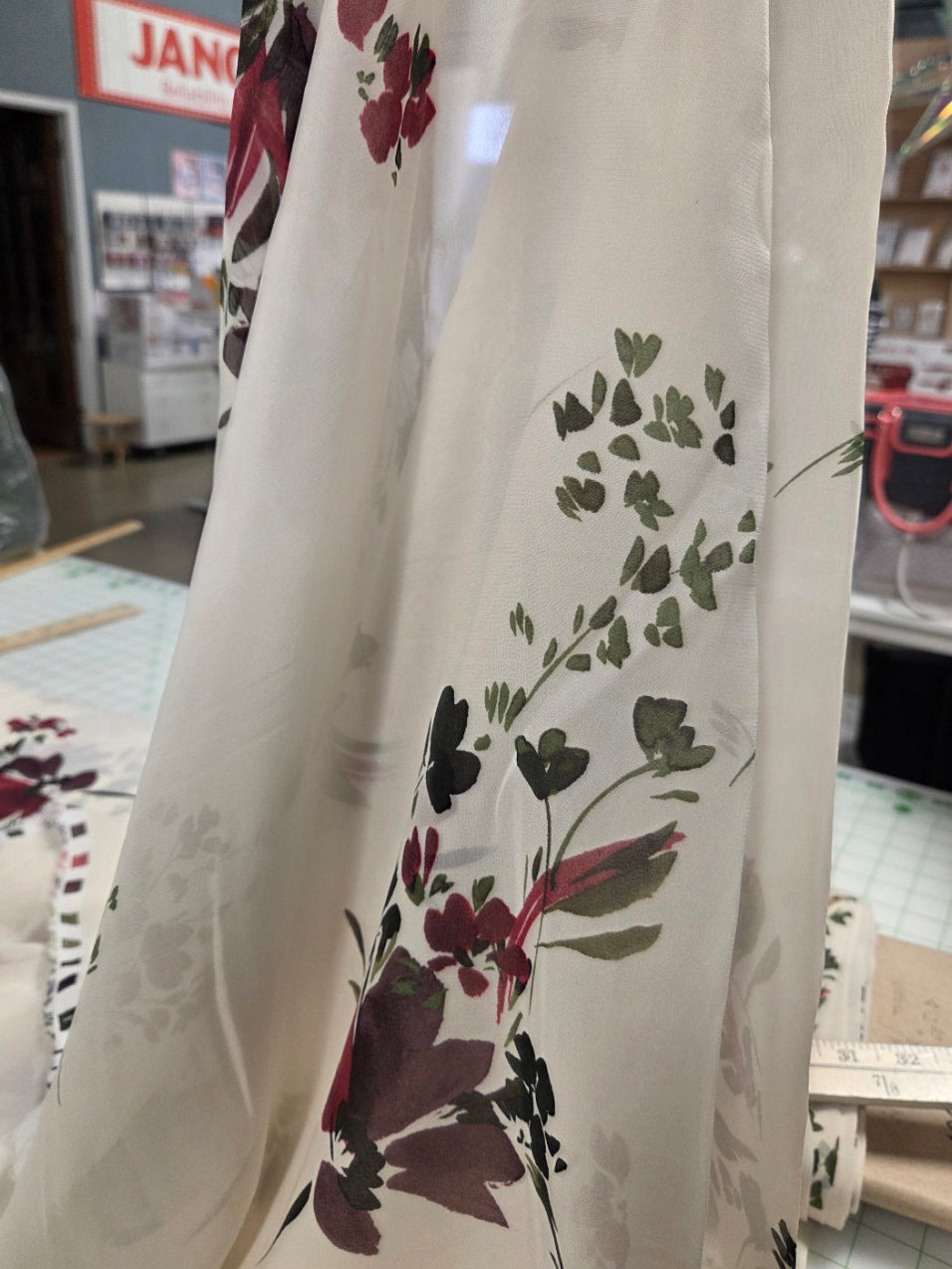 Floral-patterned fabric with red and green design on a plain background