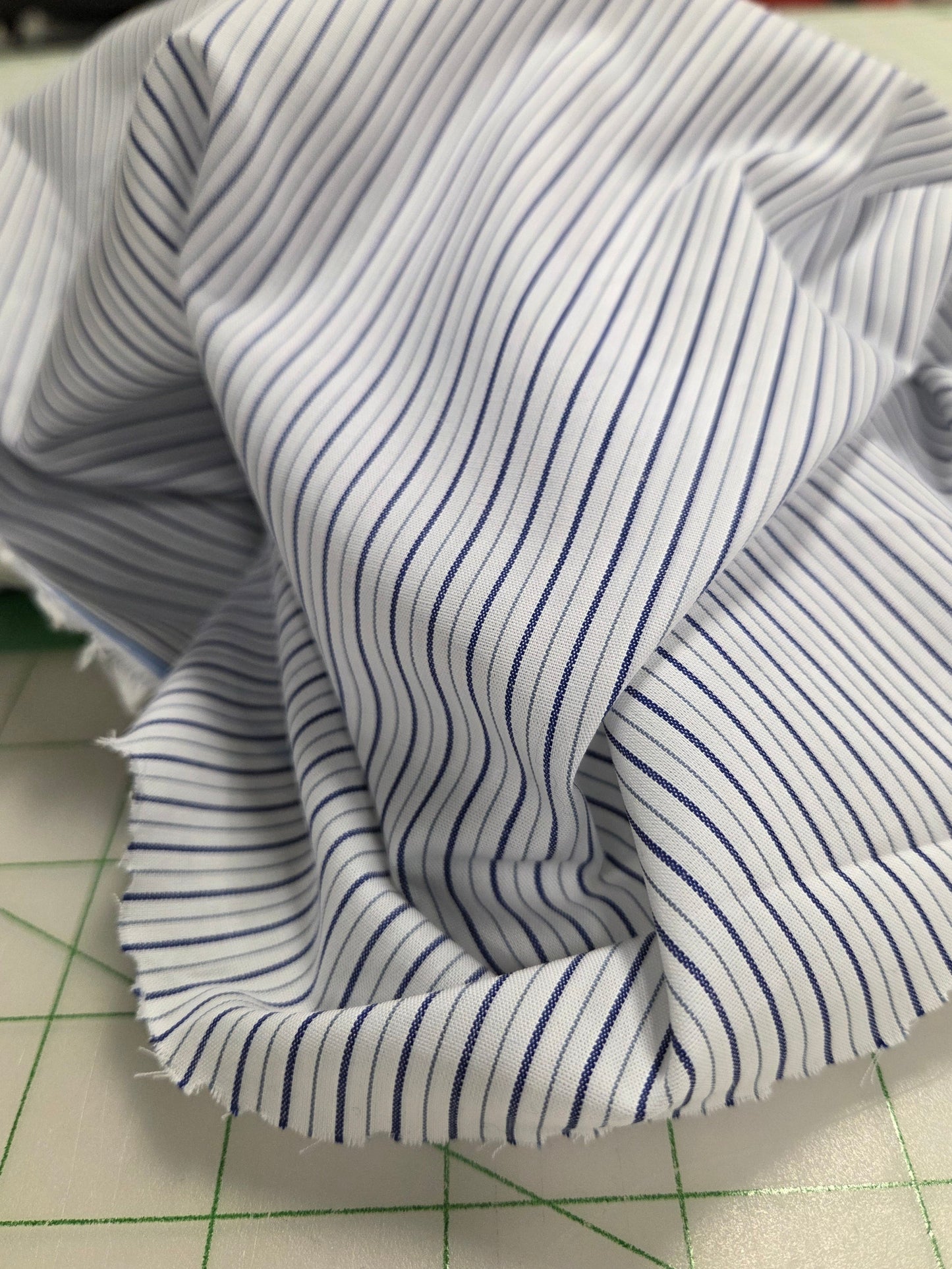 Striped fabric on a cutting mat with grid lines