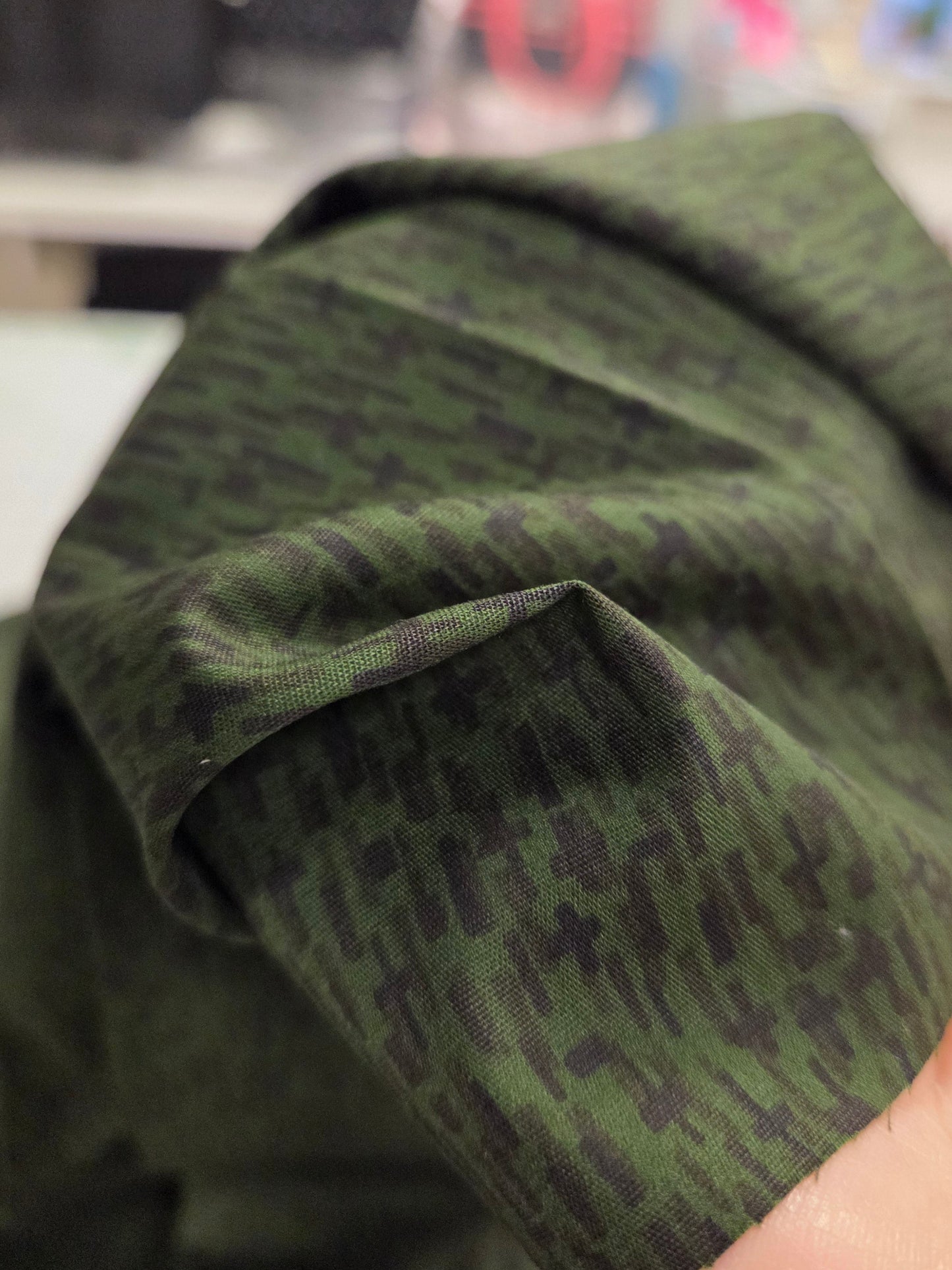 Close-up of a green camouflage-patterned sleeve with a blurred background