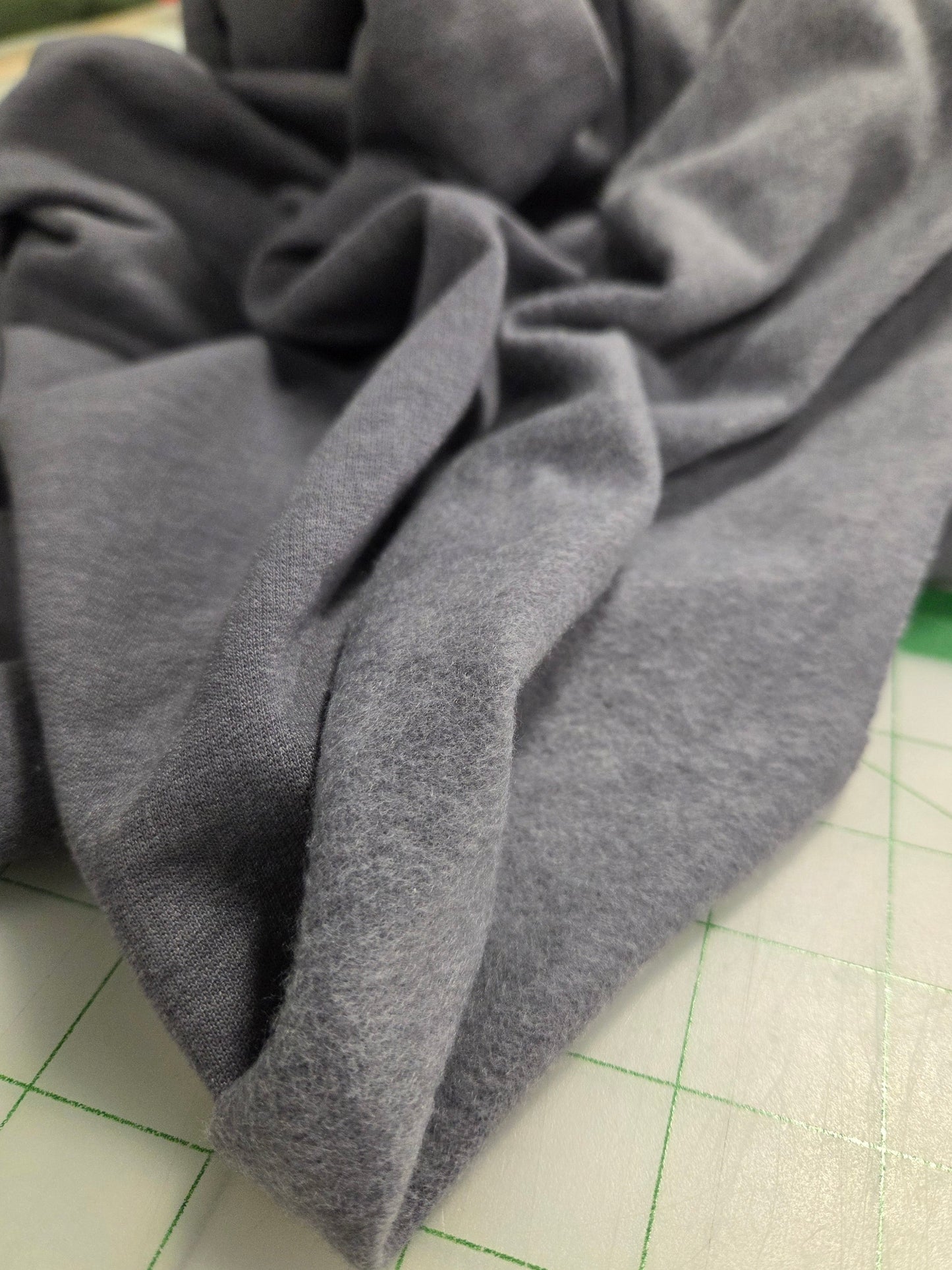 Gray fabric on a cutting mat with grid lines