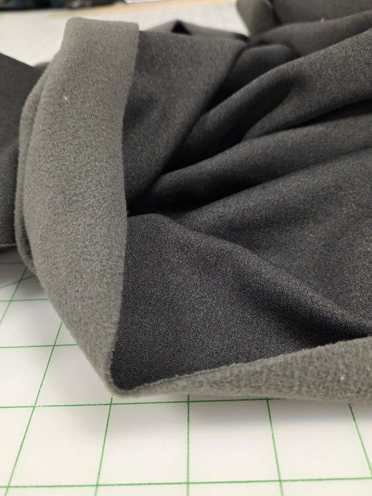 Gray coat with a textured collar against a white background with green grid lines