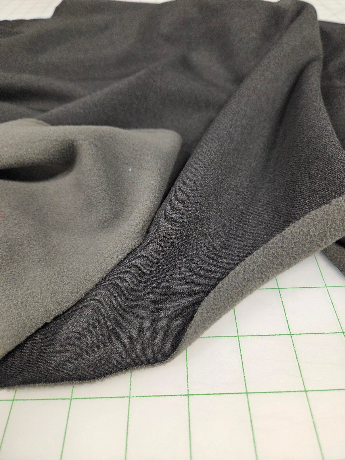 Gray fabric on a white surface with green grid lines