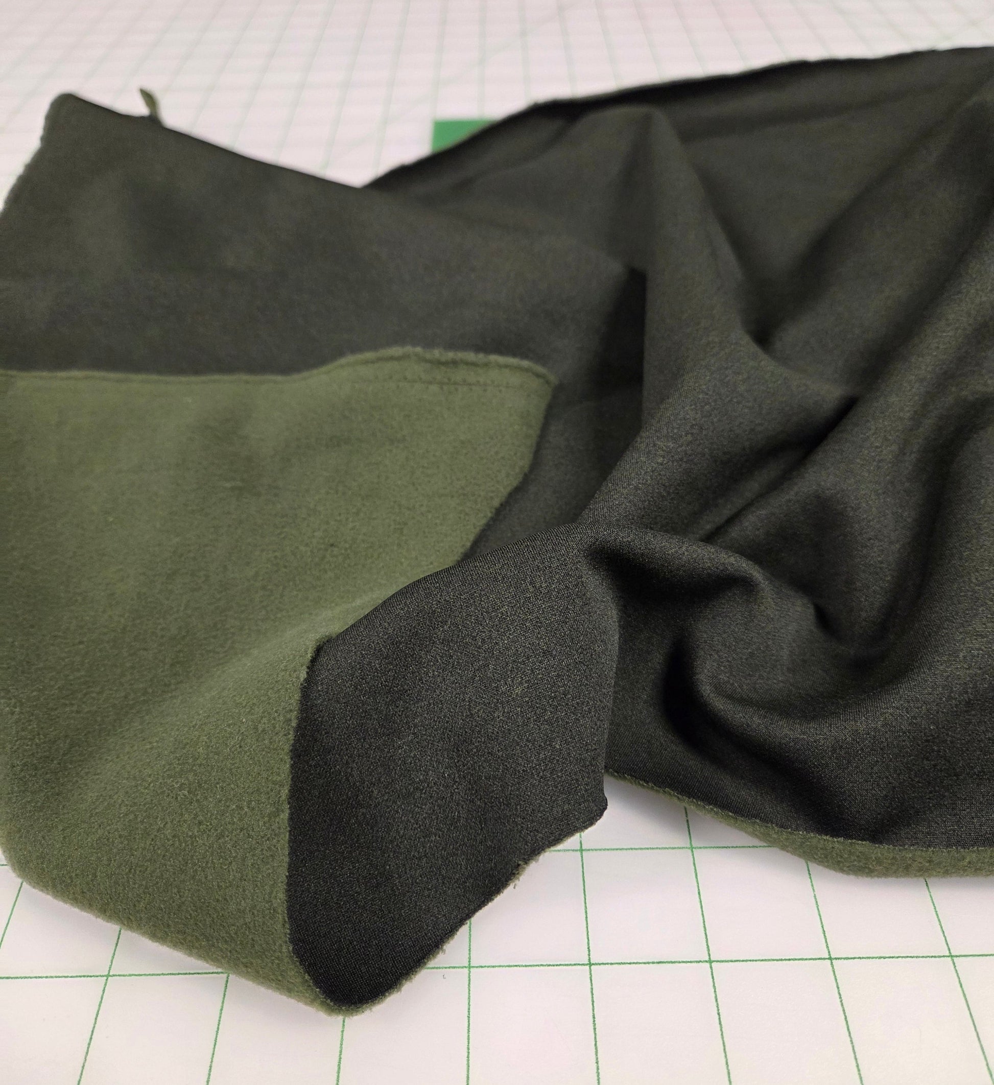 Green fabric with black border on a white background