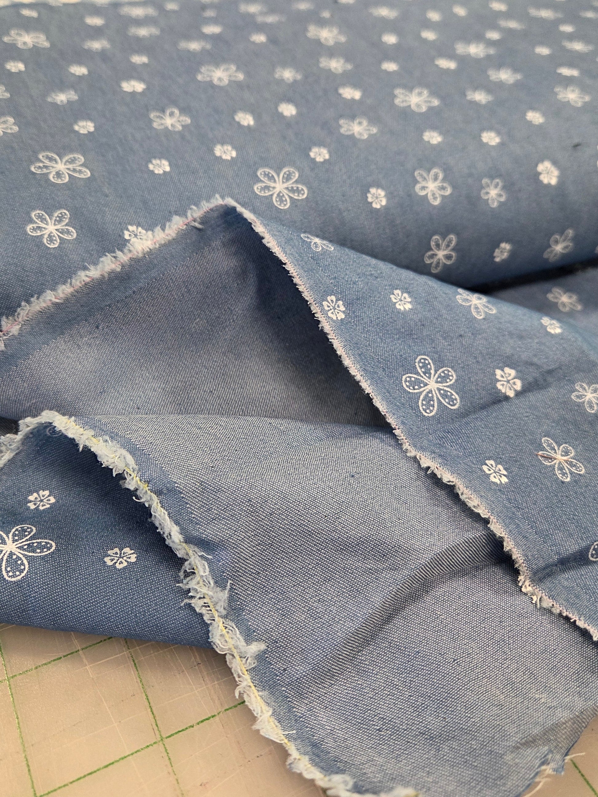 Blue fabric with white floral patterns on a tiled floor background