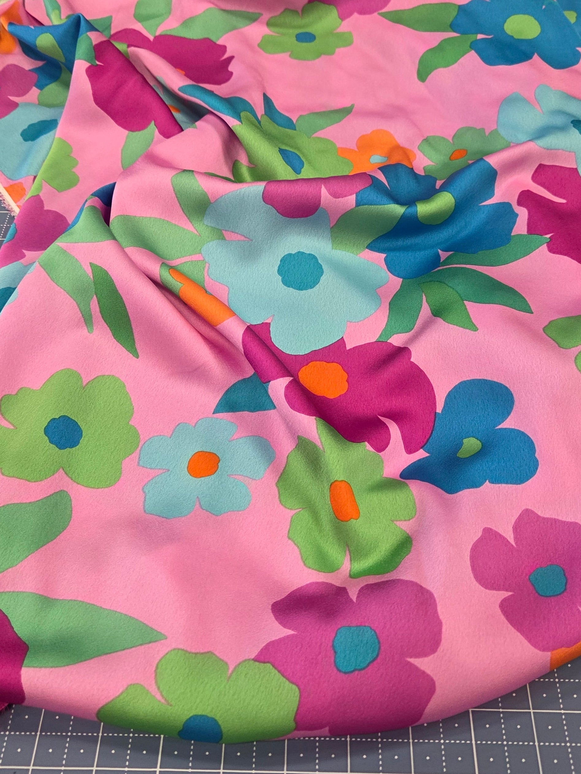 Floral-patterned fabric on a cutting mat with scissors in the background
