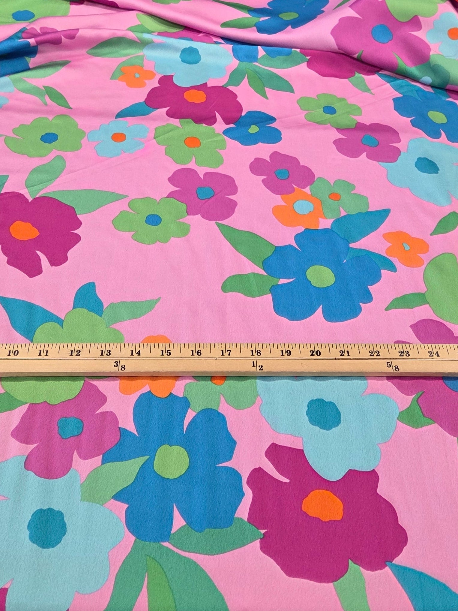 Floral-patterned fabric on a rack with a measuring tape