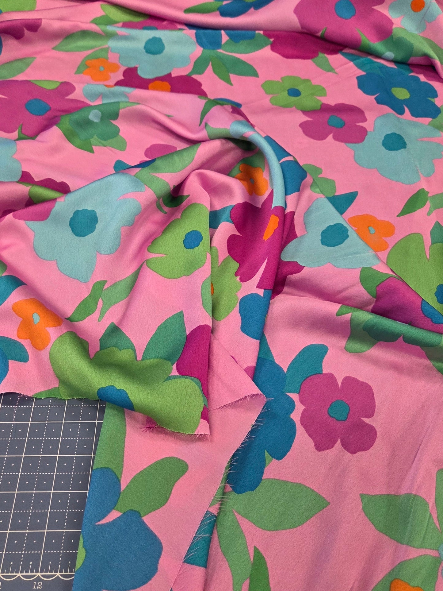 Colorful floral fabric on a cutting mat with a ruler