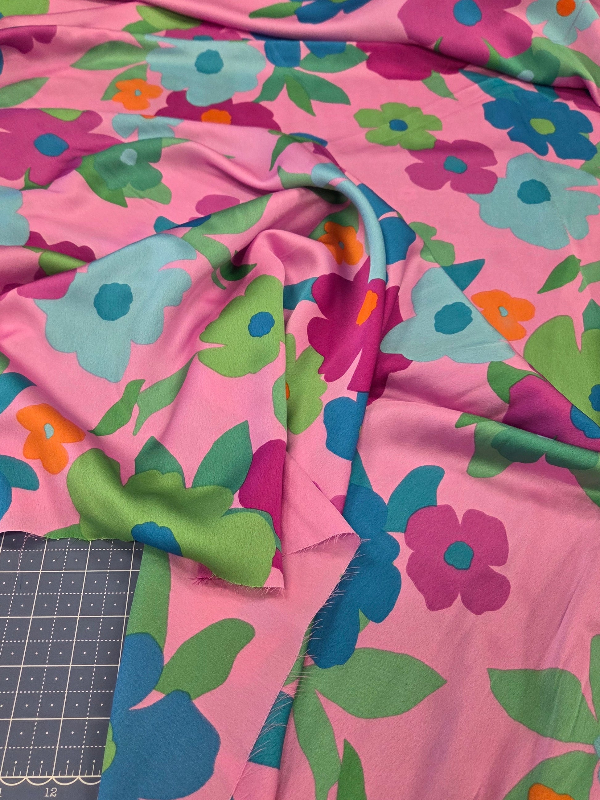 Colorful floral fabric on a cutting mat with a ruler
