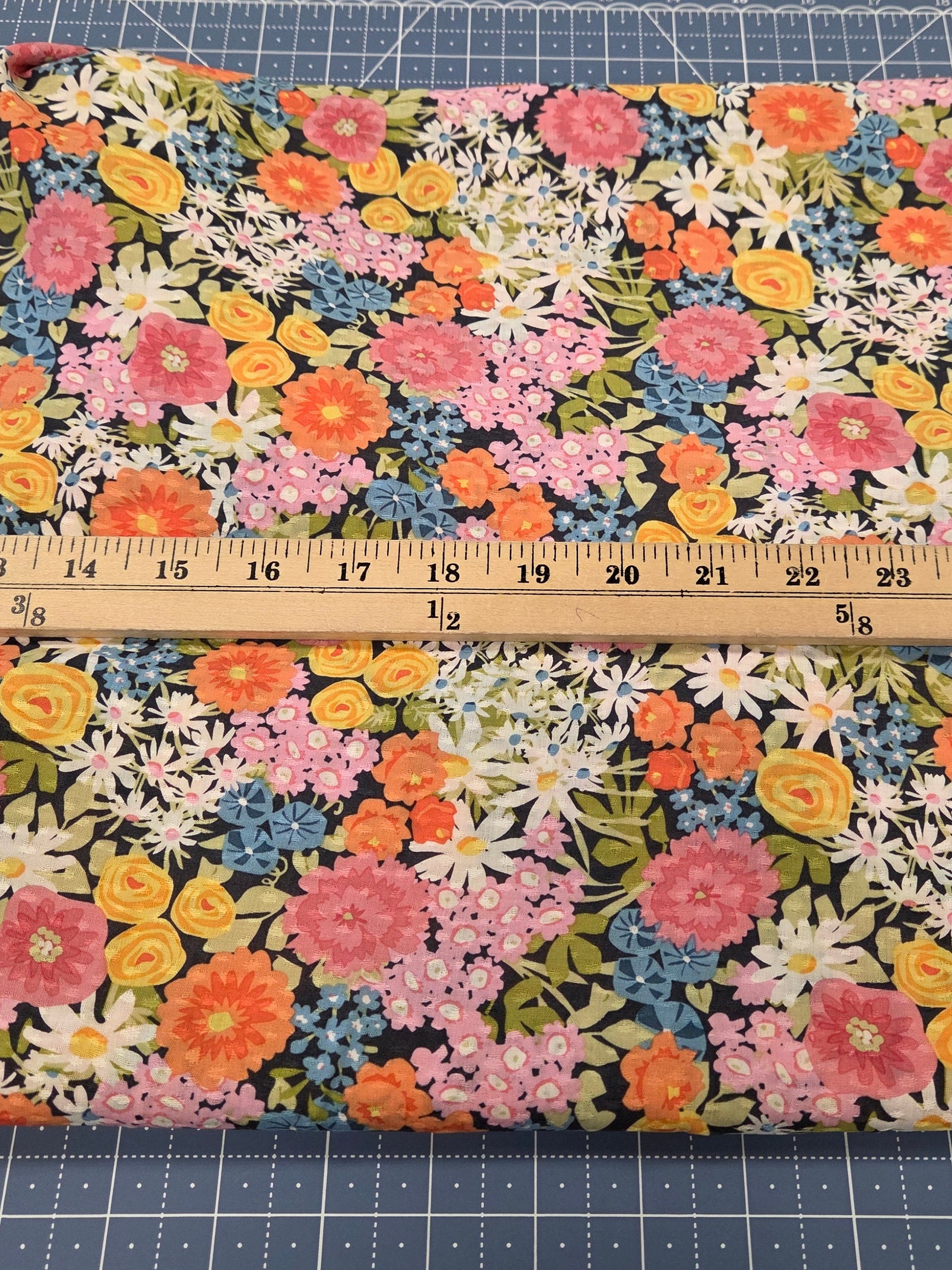 Floral fabric with a ruler for scale on a cutting mat