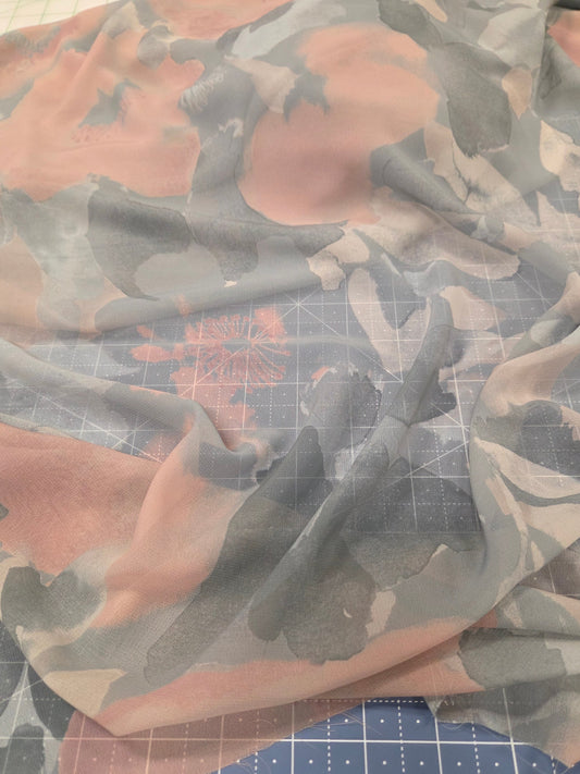 Camouflage-patterned fabric on a cutting mat with grid lines