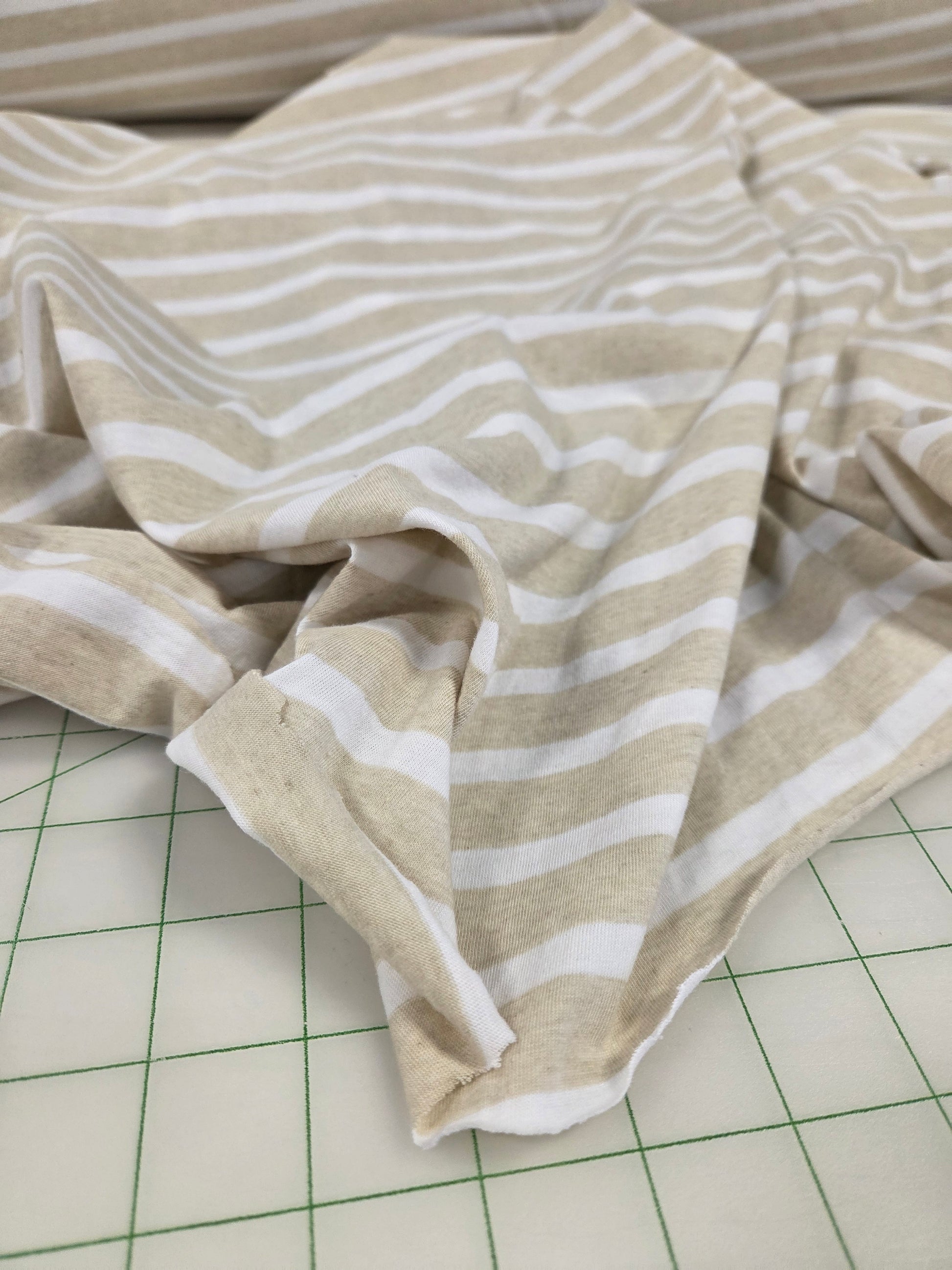 Beige and white striped fabric on a grid background