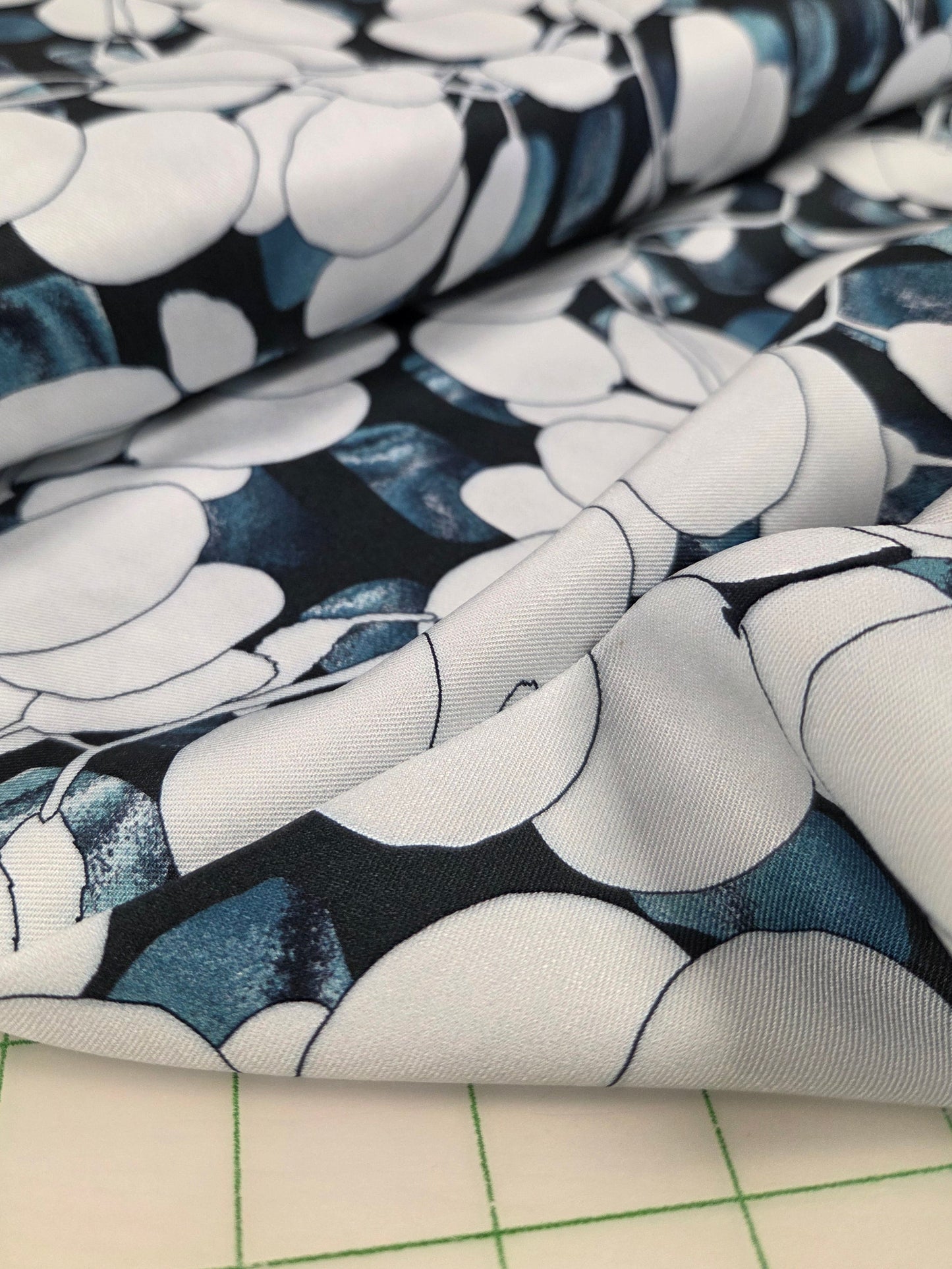 Close-up of floral-patterned fabric on a grid background. OEKO tex certified 