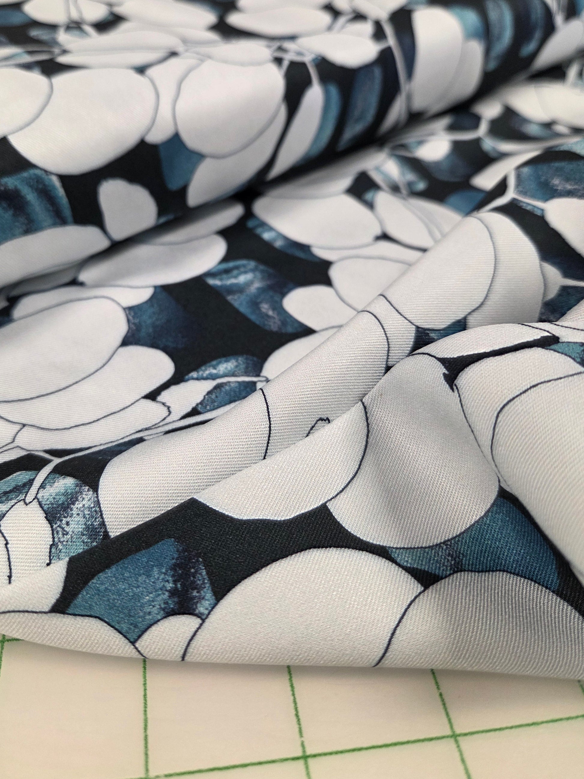 Close-up of floral-patterned fabric on a grid background. OEKO tex certified 