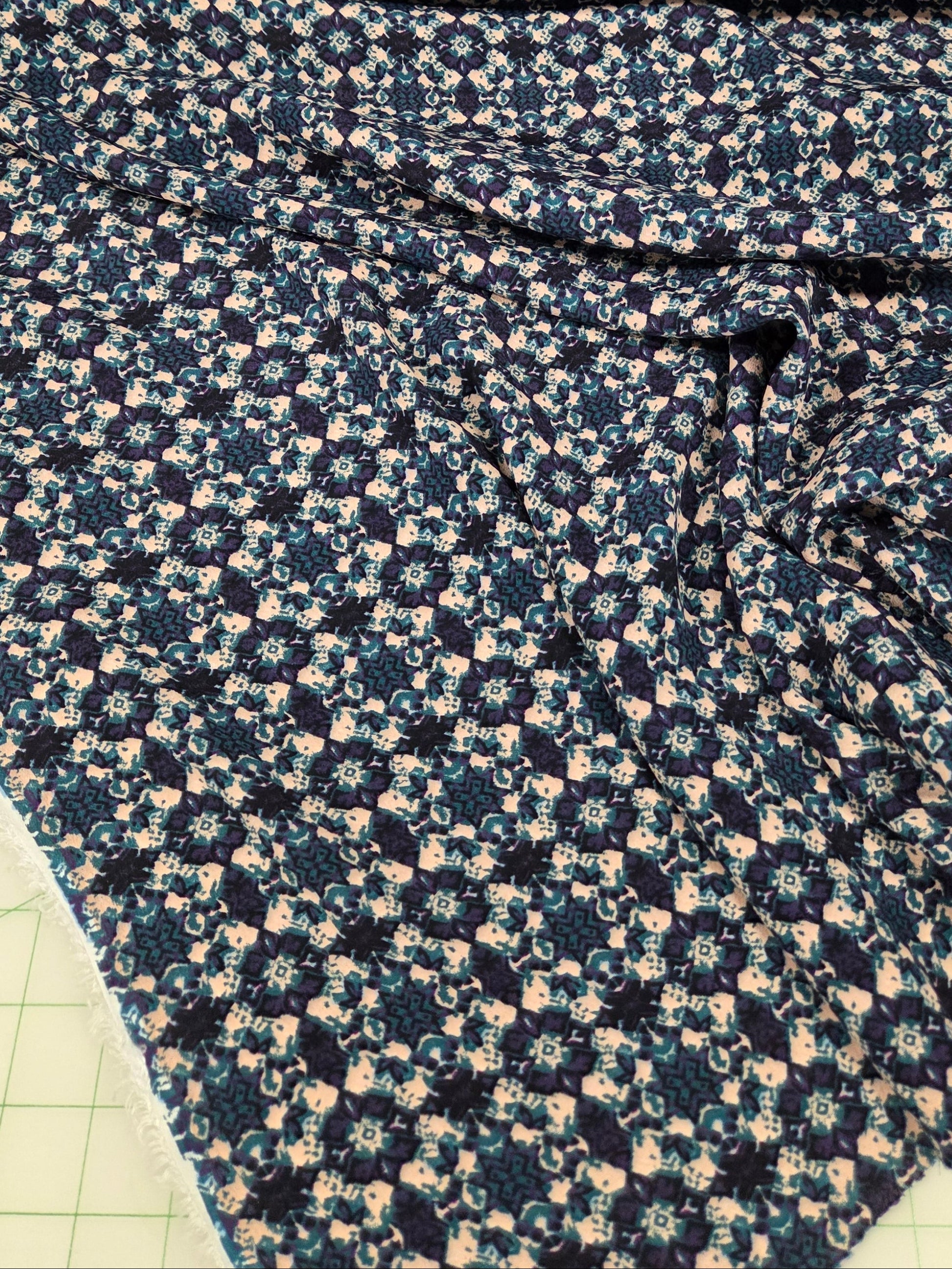 Rolls of floral fabric on a cutting mat