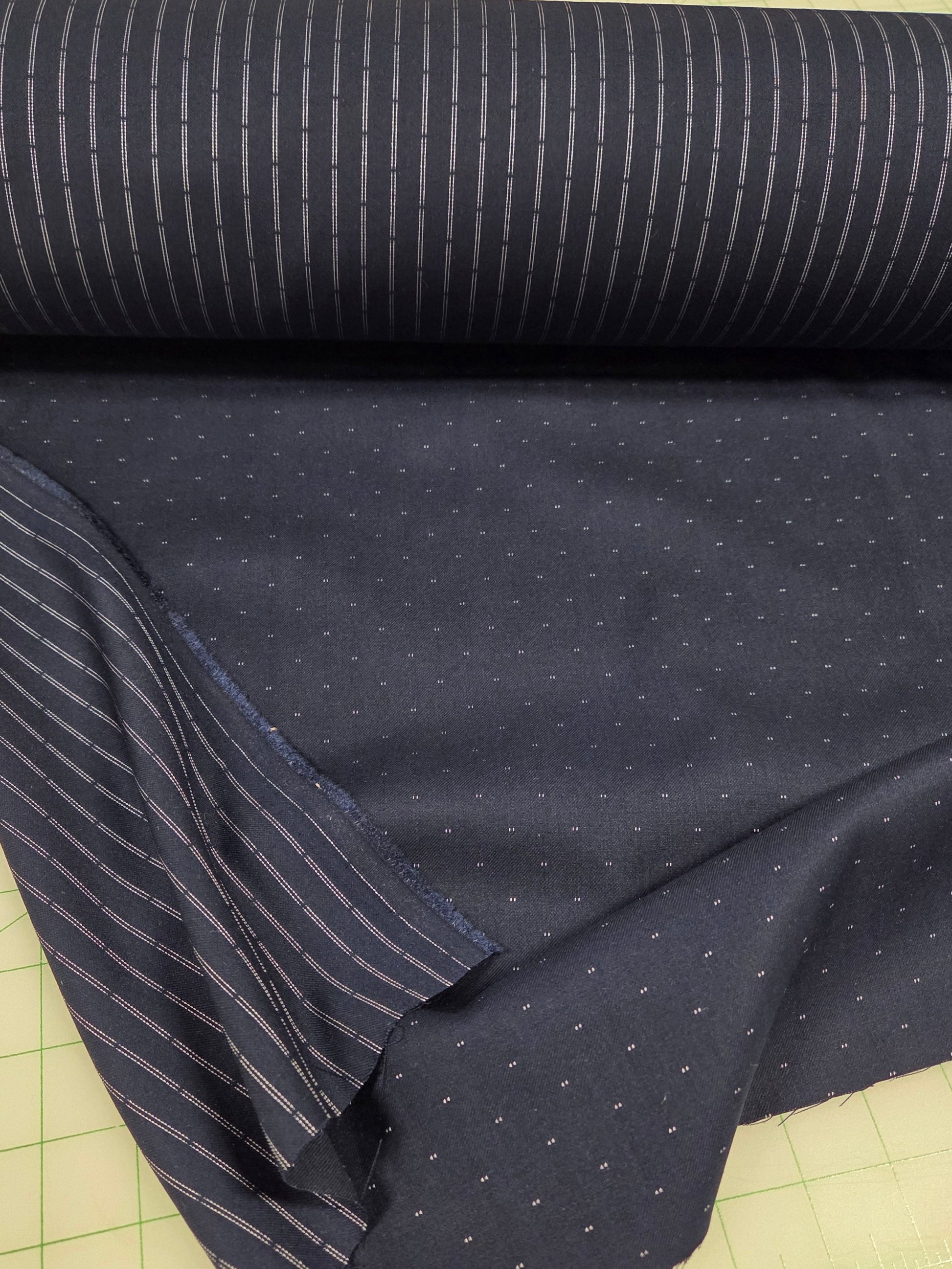 Dark blue fabric with subtle pattern on a green cutting mat