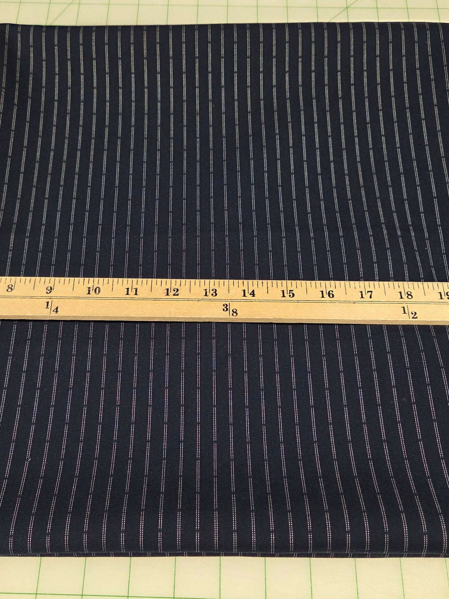 Dark fabric with a ruler for scale on a grid background