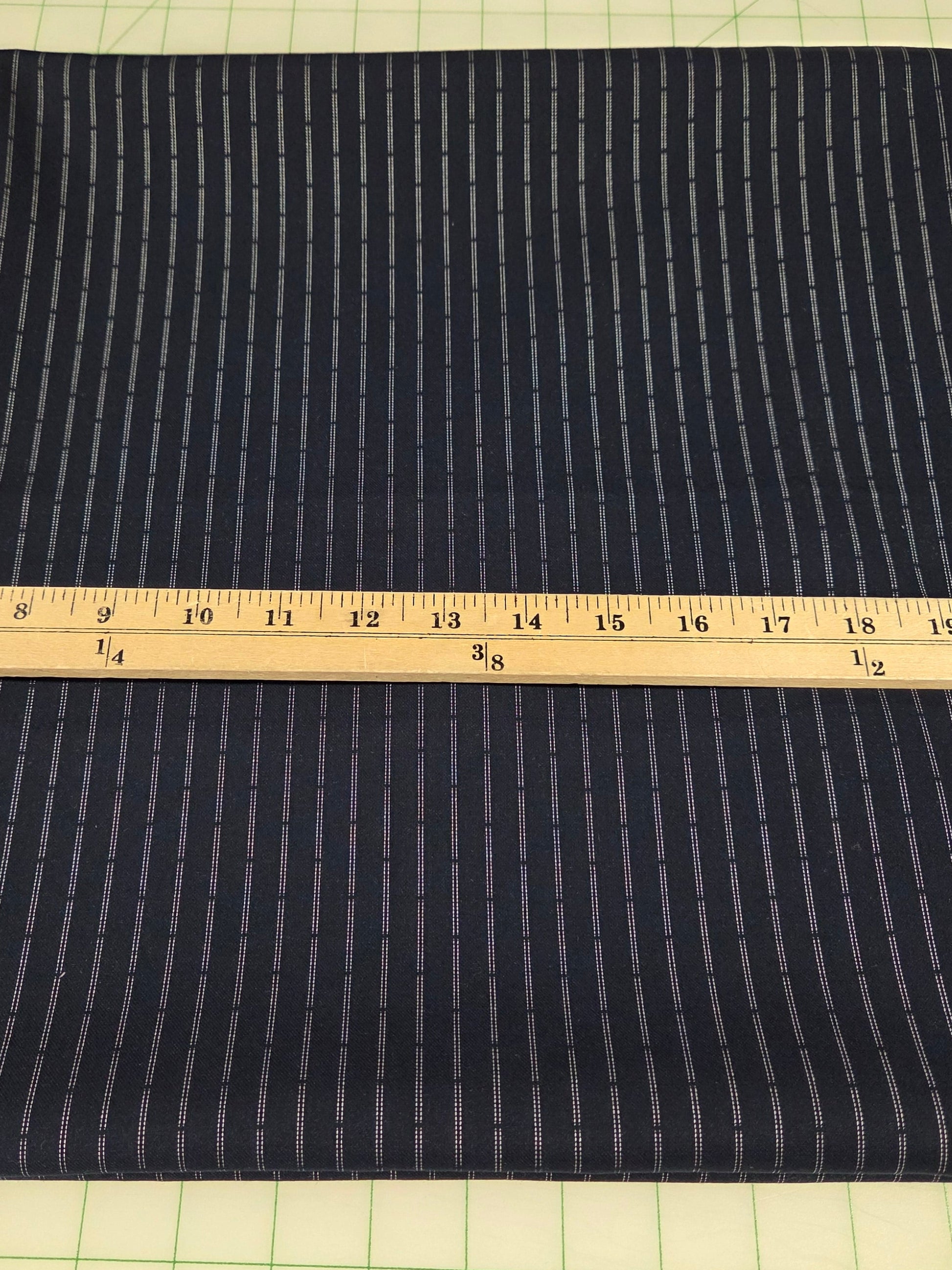Dark fabric with a ruler for scale on a grid background