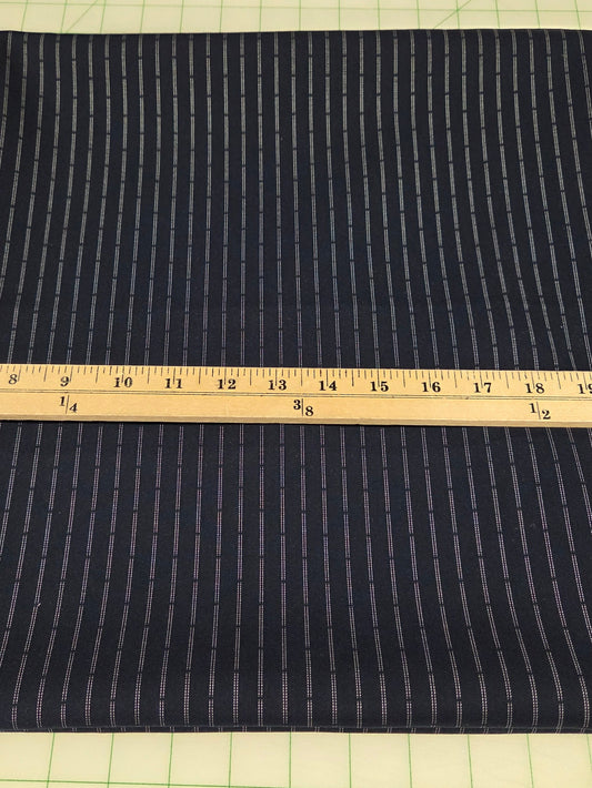 Dark fabric with a ruler for scale on a grid background