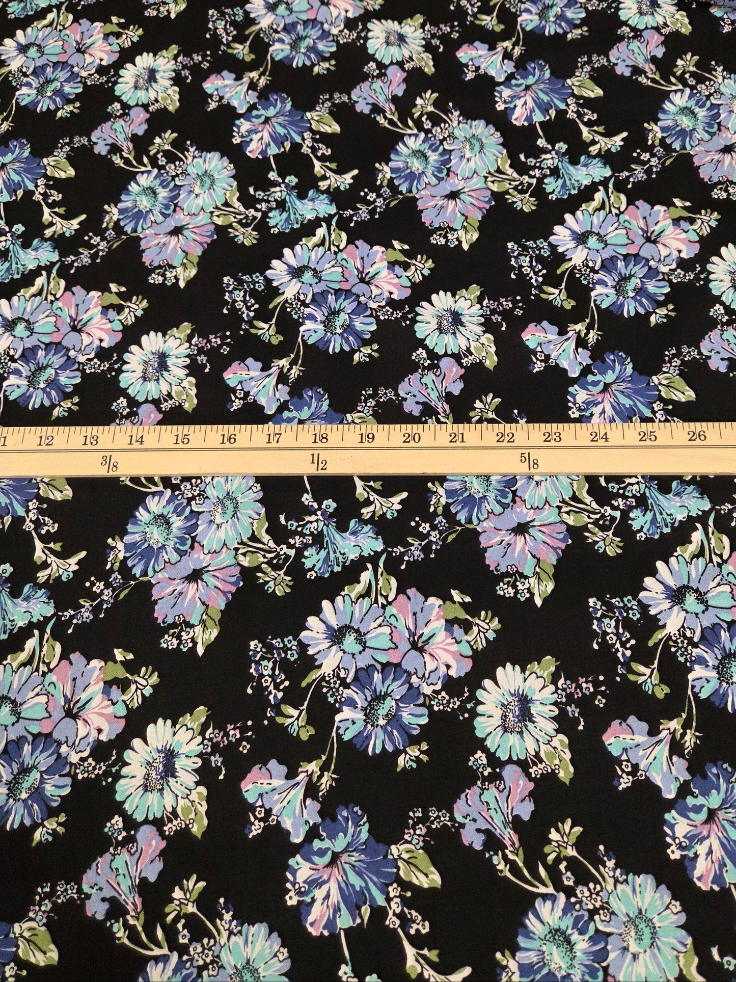 Floral fabric pattern with a ruler for scale on a black background