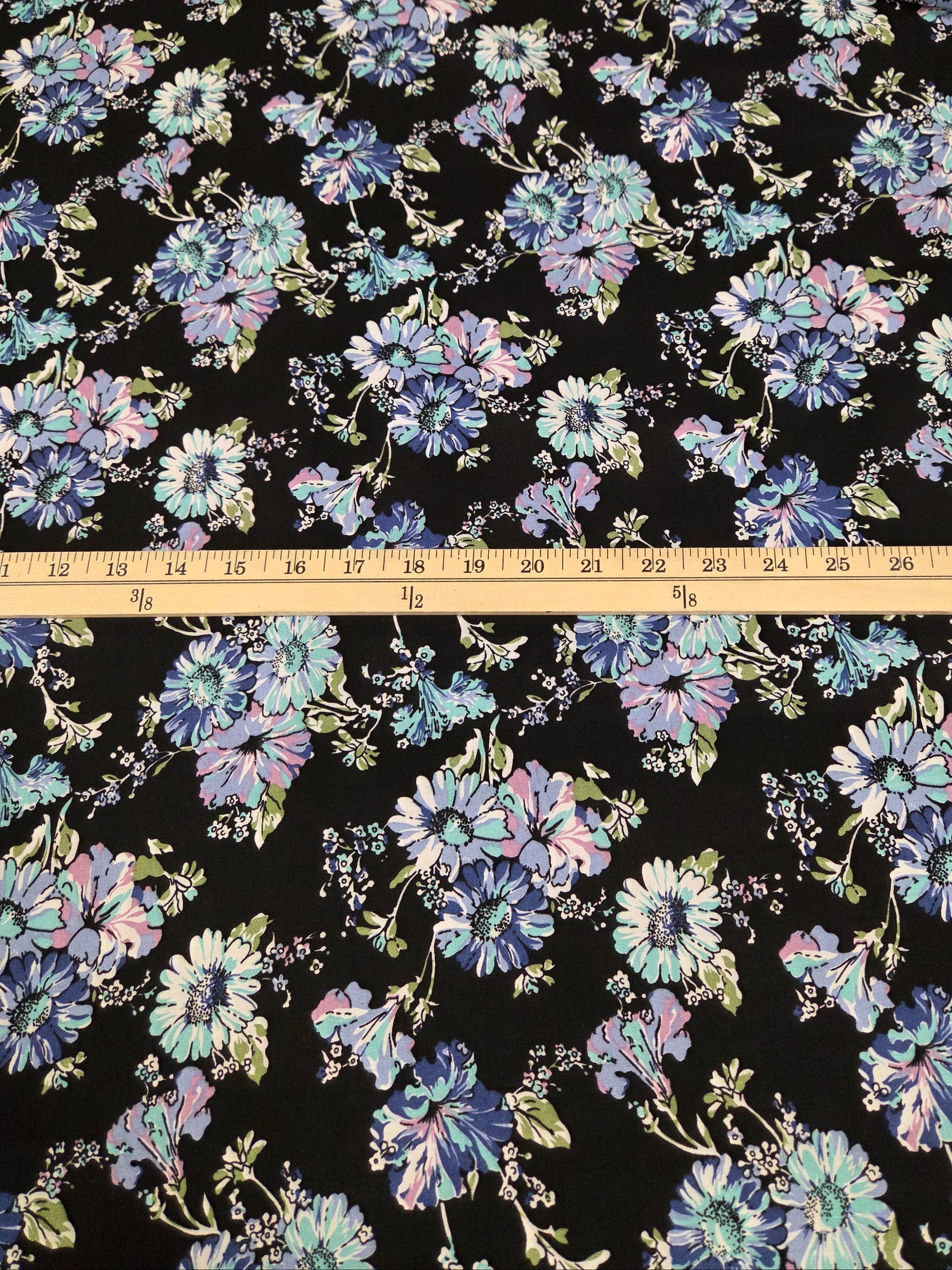 Floral fabric pattern with a ruler for scale on a black background