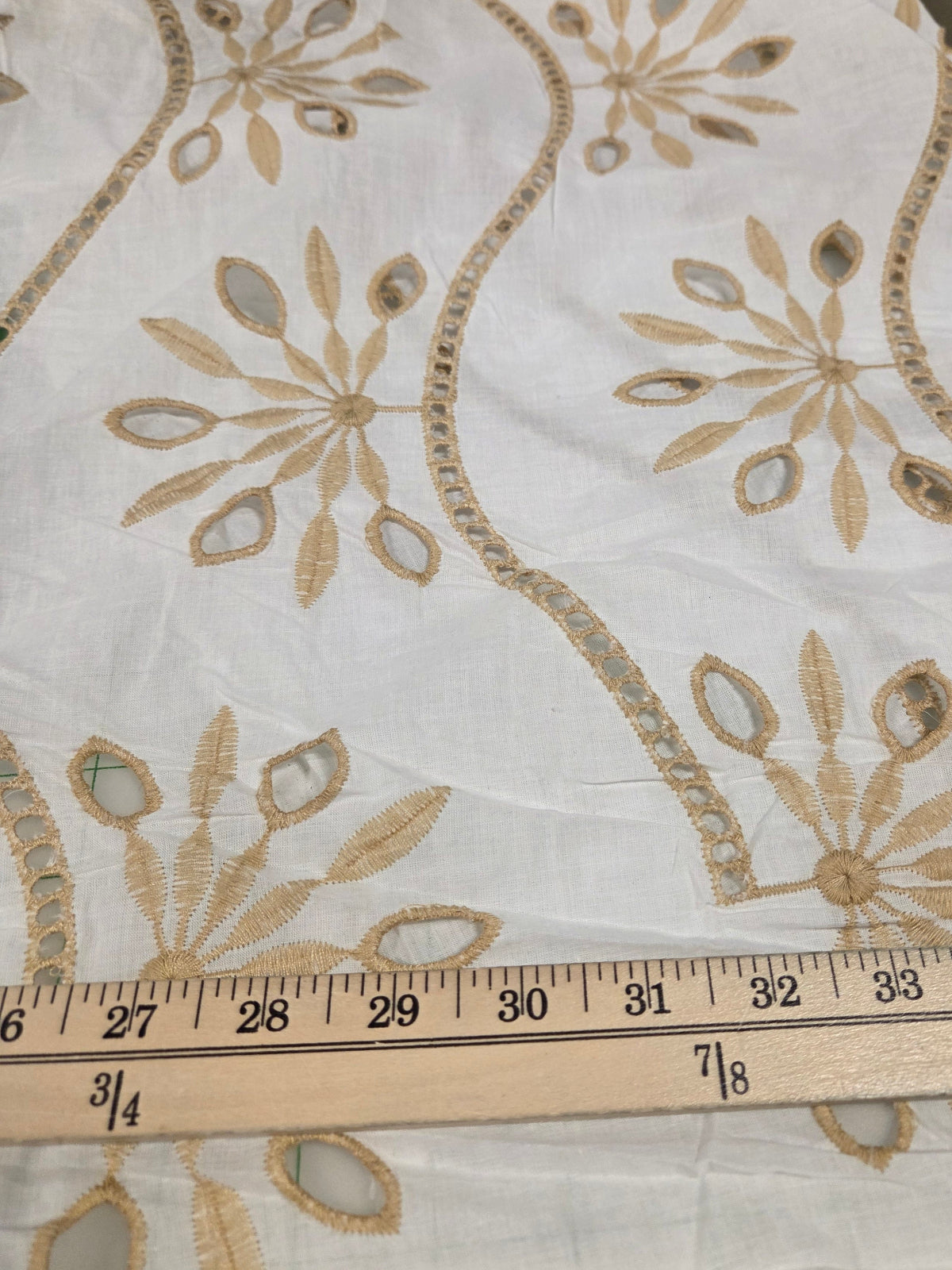 Embroidered fabric with a ruler for scale on a neutral background