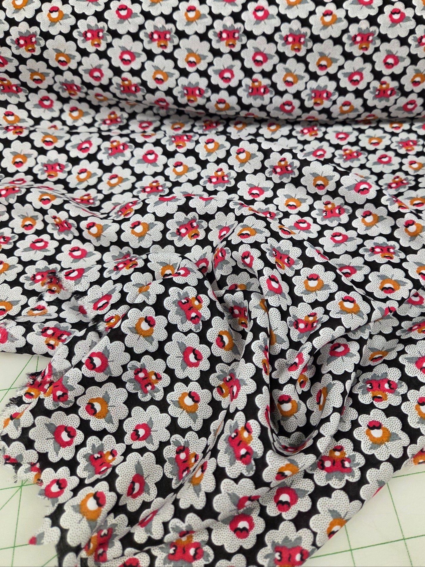 Floral fabric with small flowers on a black background, cut into strips.