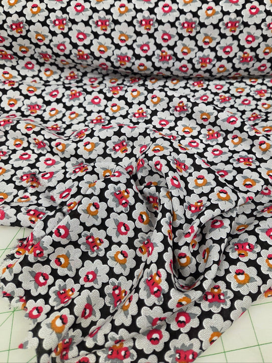 Floral fabric with small flowers on a black background, cut into strips.