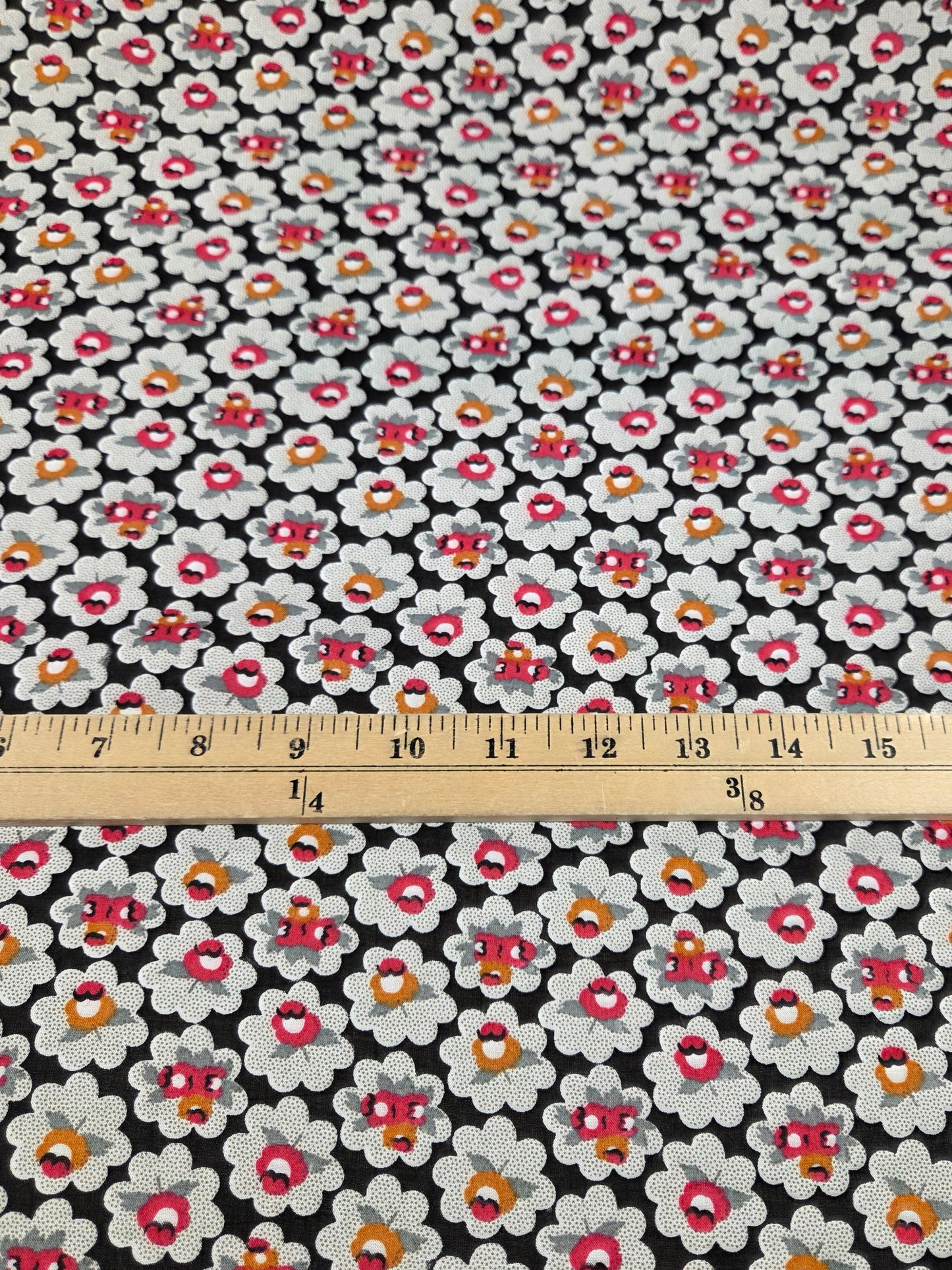 Floral fabric with a ruler for scale on a black background