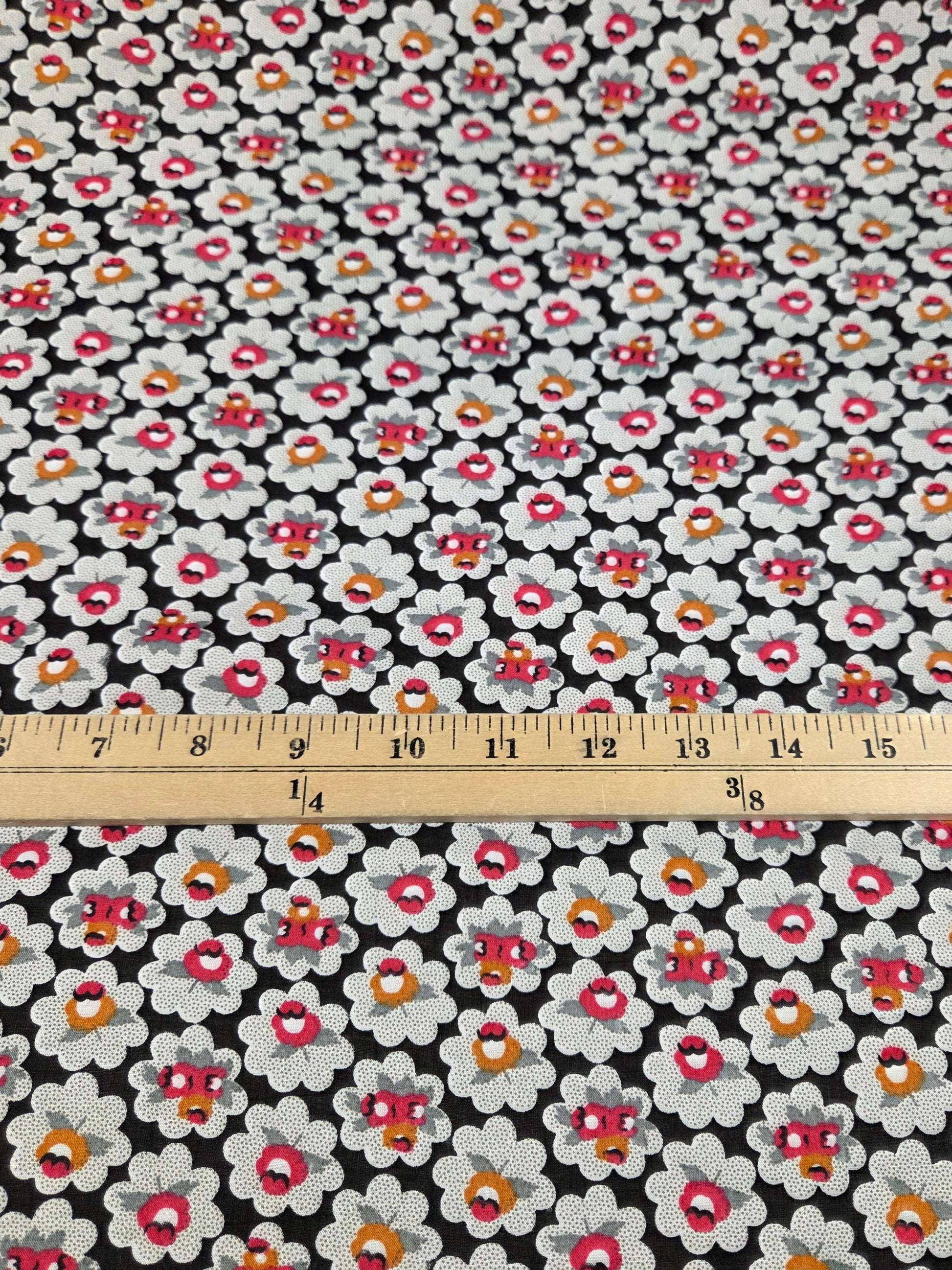 Floral fabric with a ruler for scale on a black background