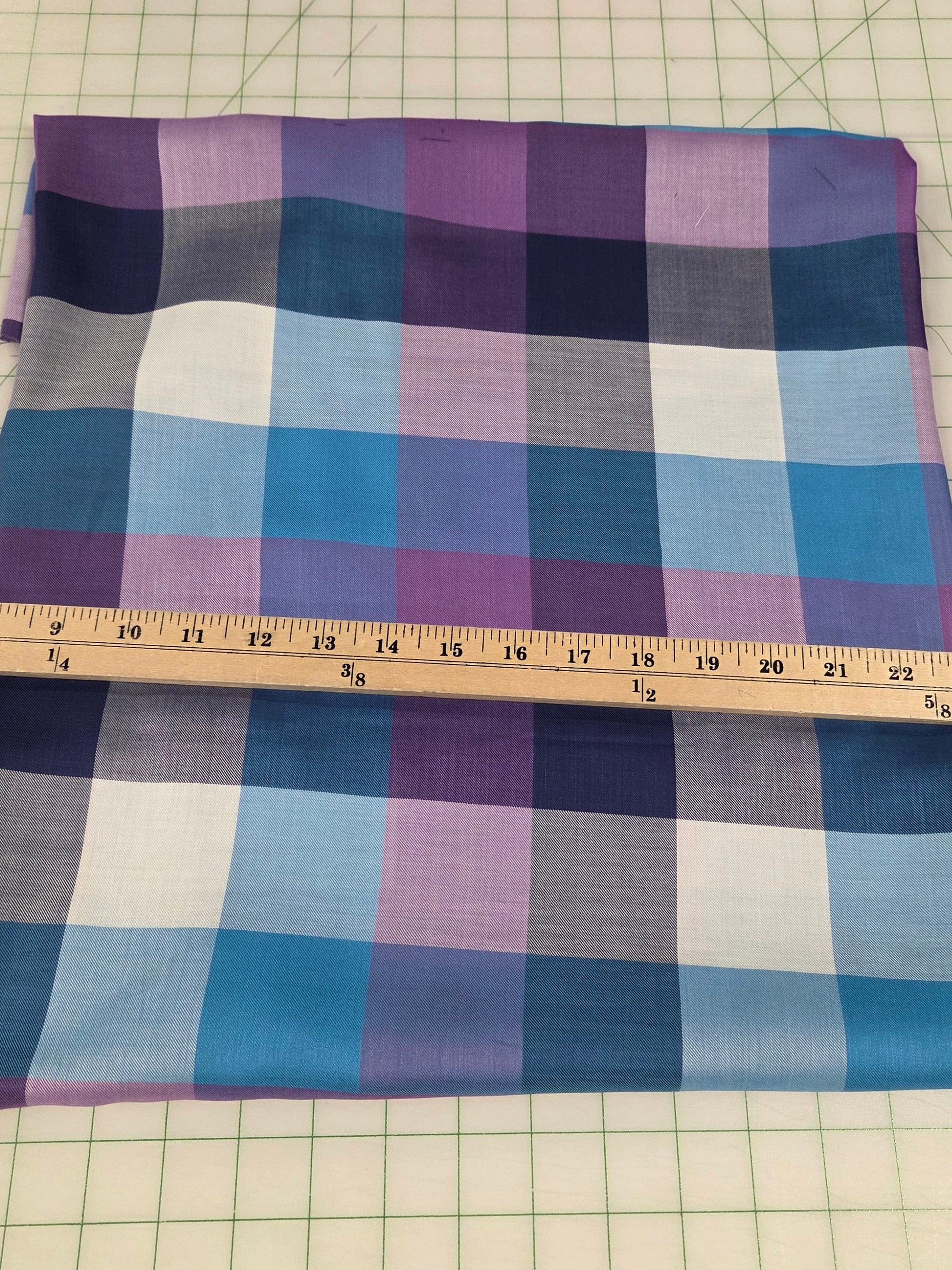 Plaid fabric with a ruler for measurement on a grid background
