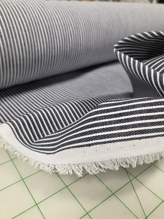 Striped fabric with frayed edge on a cutting mat