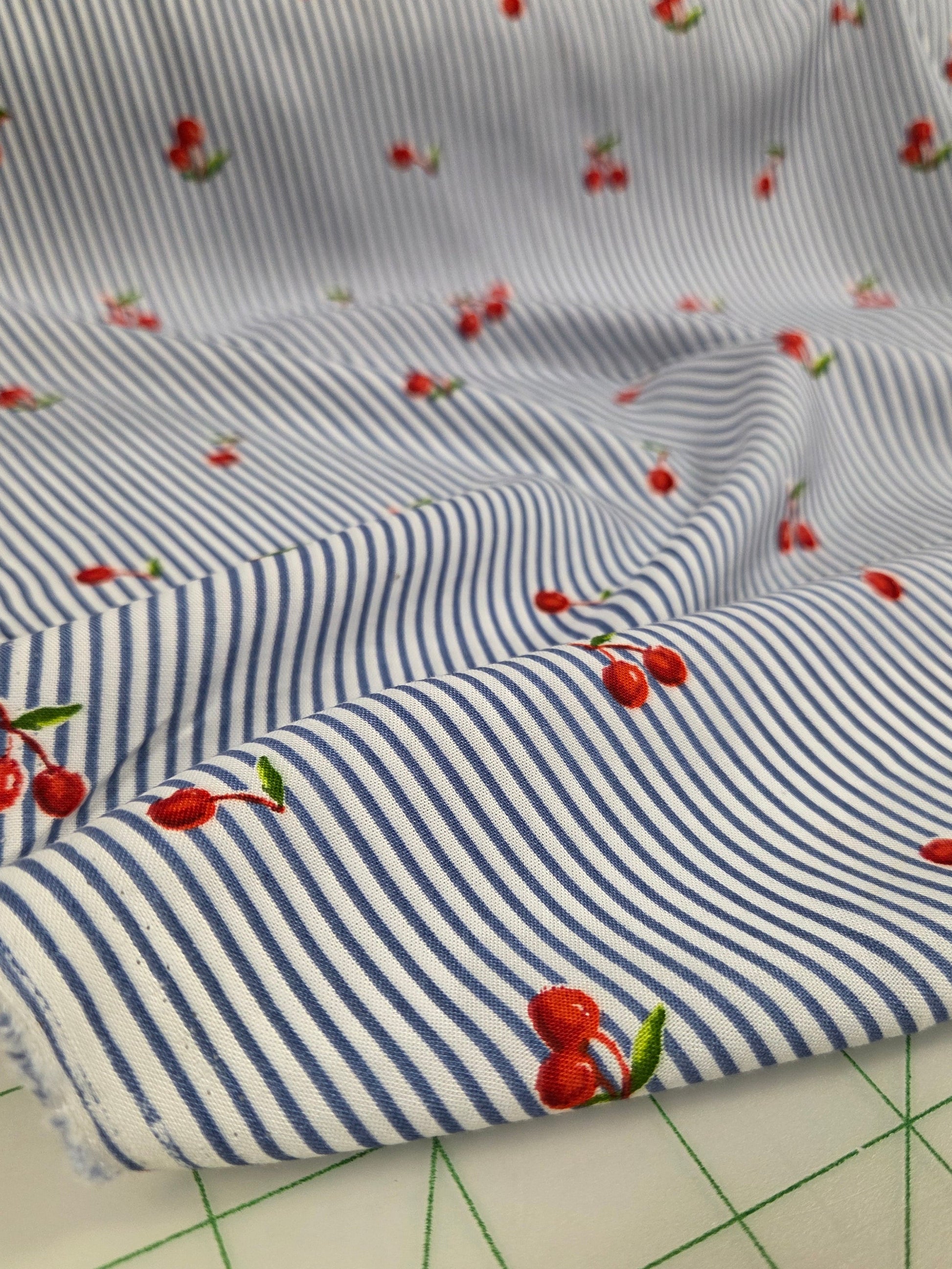 Striped fabric with cherry pattern on a cutting mat