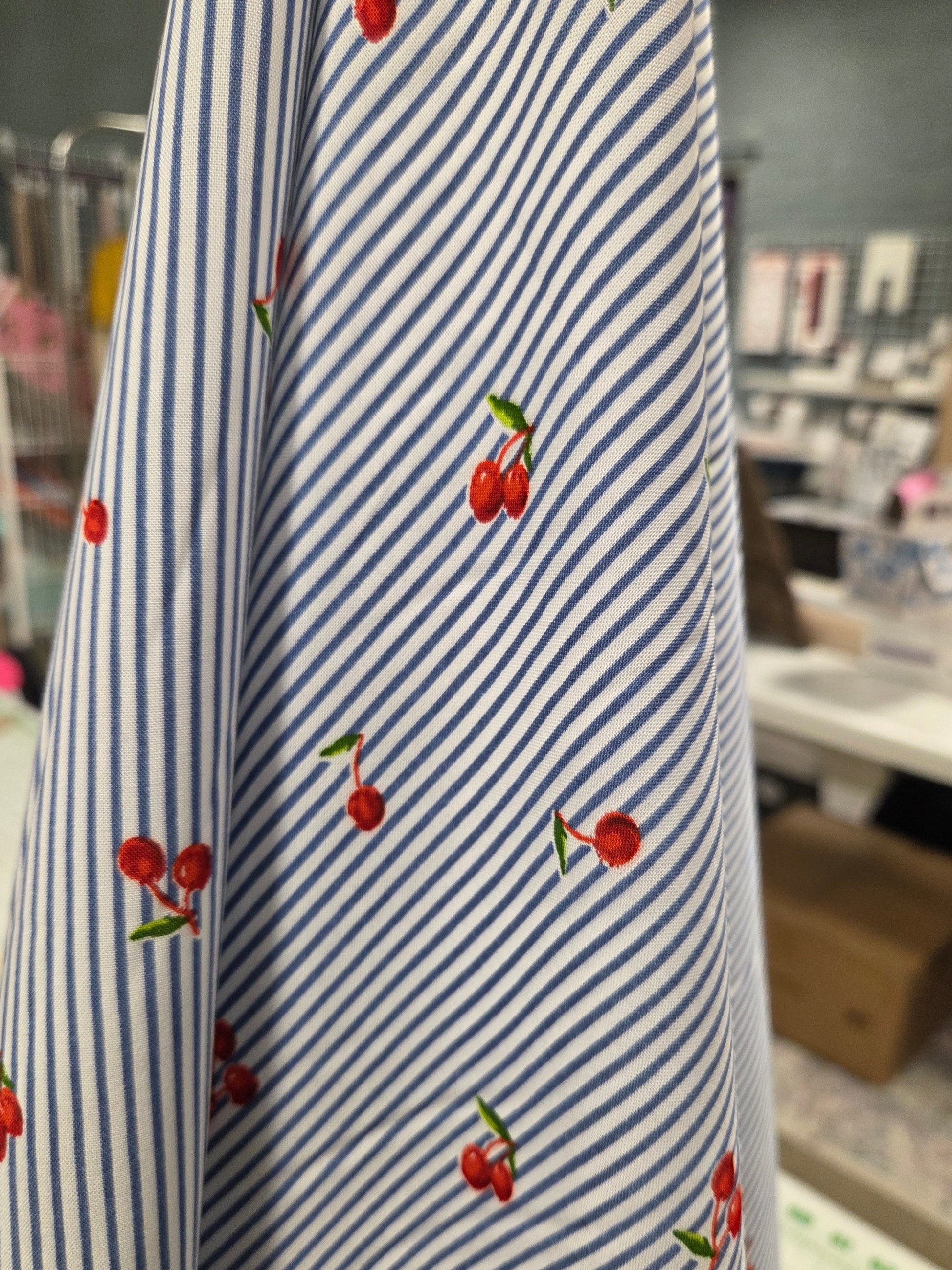 Striped fabric with cherry pattern in a store setting