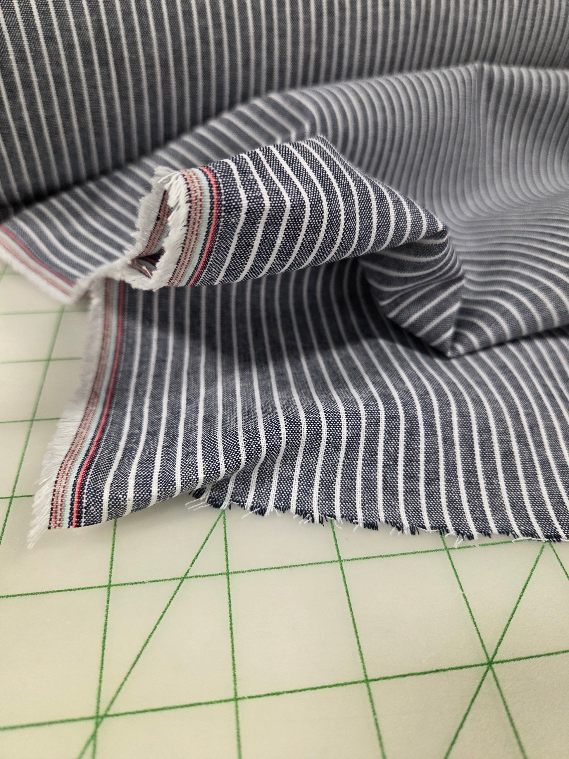 Striped fabric on a cutting mat with grid lines