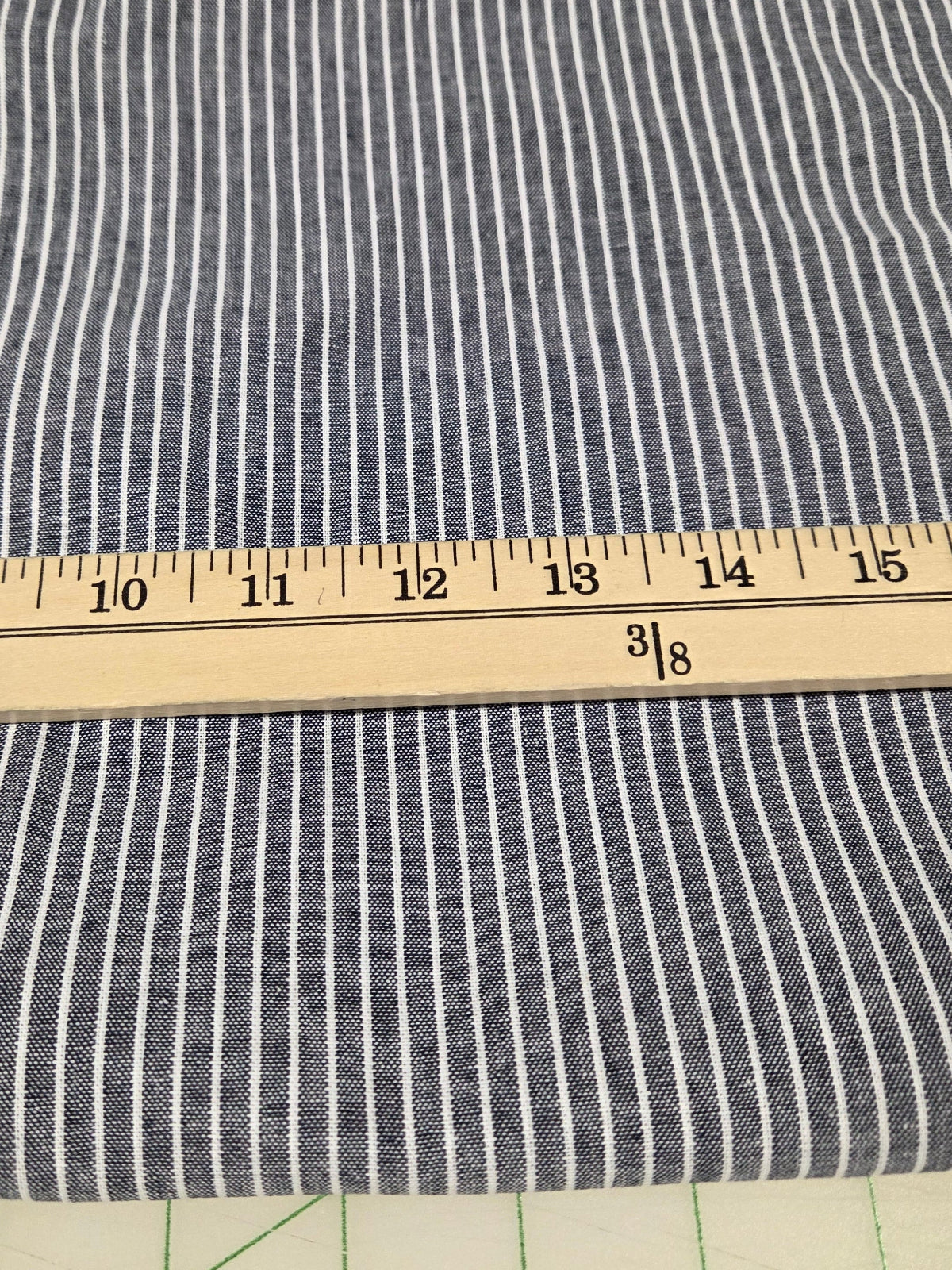 Striped fabric with a ruler for scale on a cutting mat