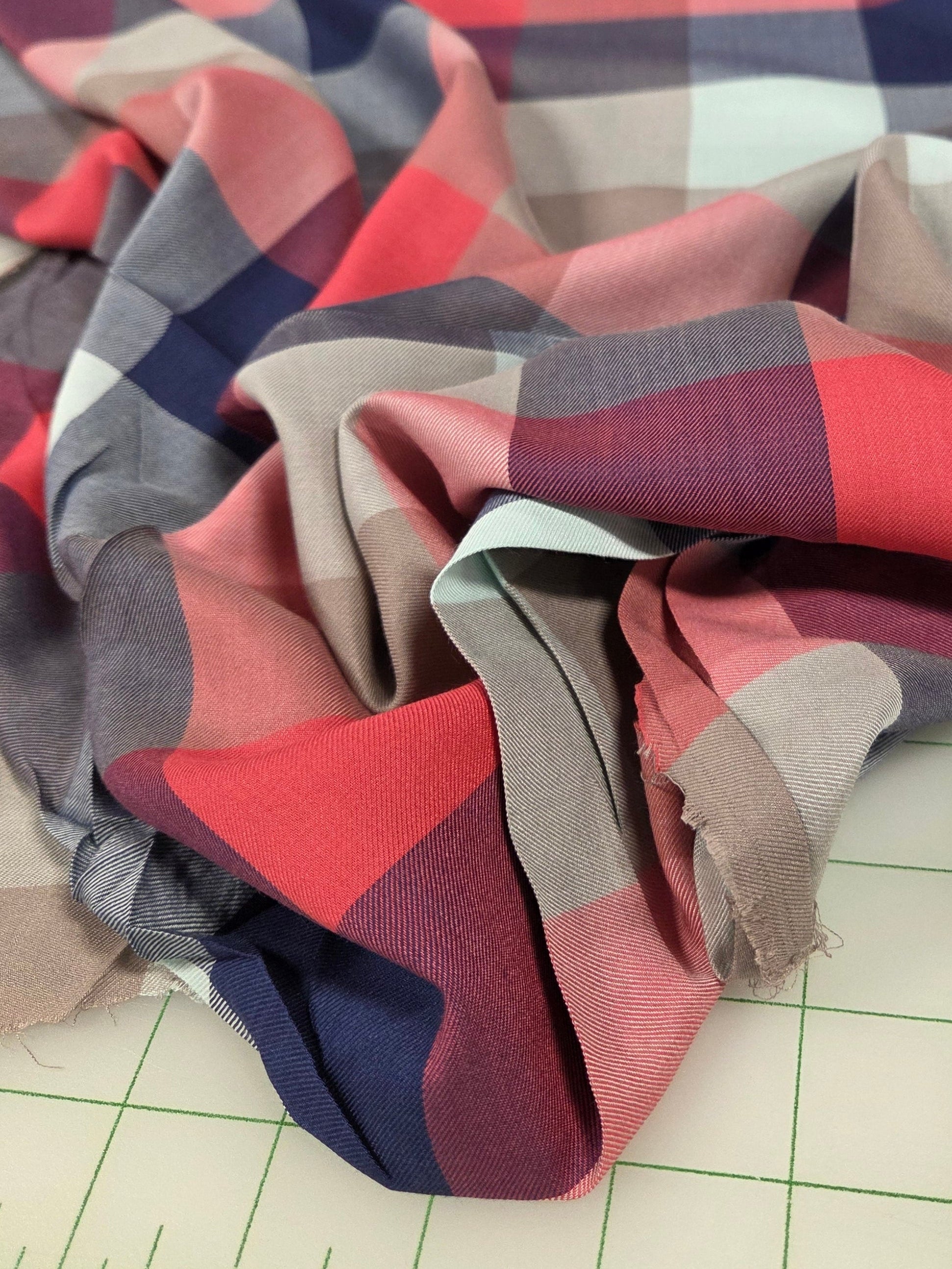 Plaid fabric with red, blue, and beige colors on a grid background