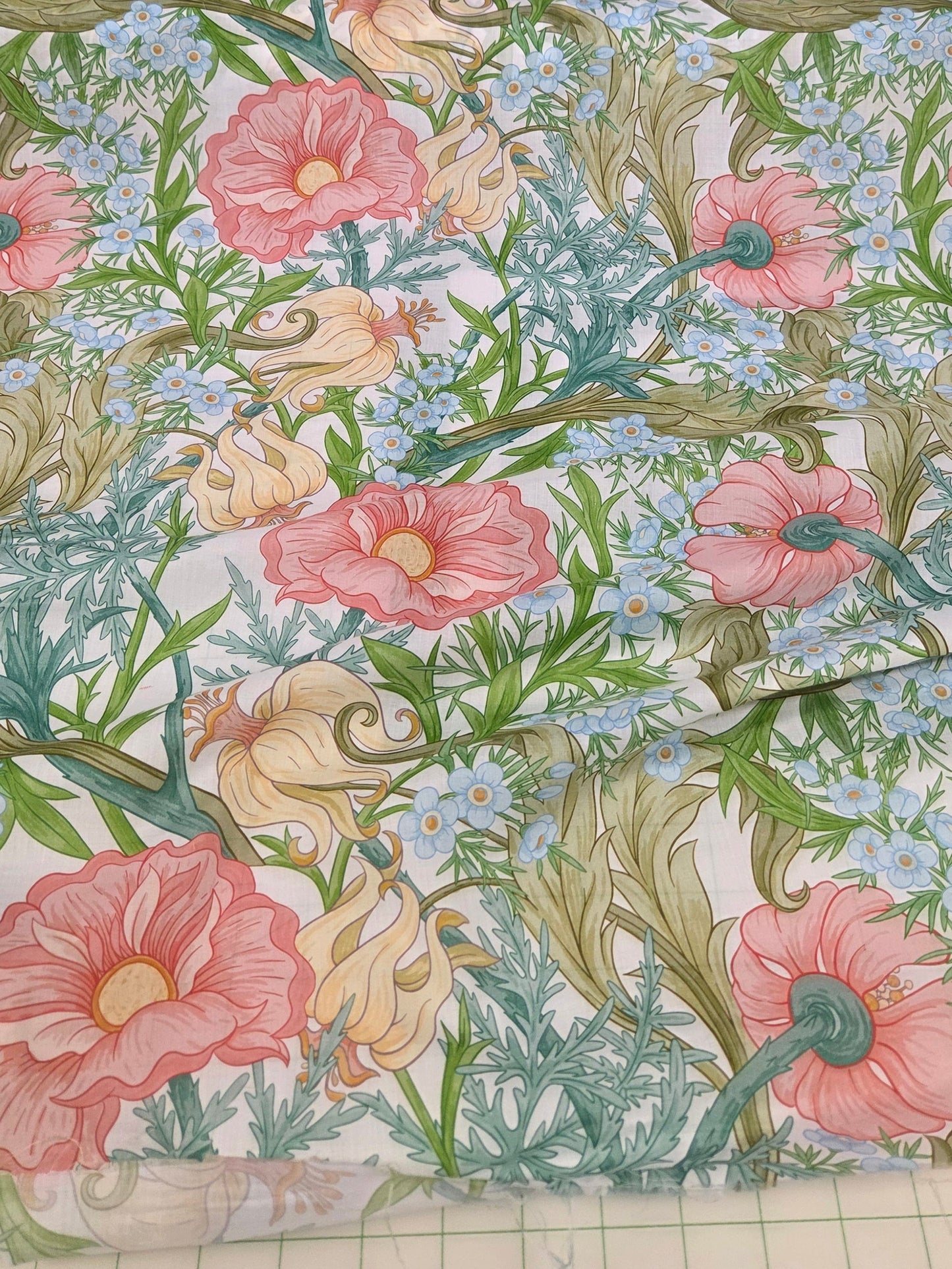 cotton linen vintage floral woven voile weight with pink, yellow and blue florals scattered on white ground.