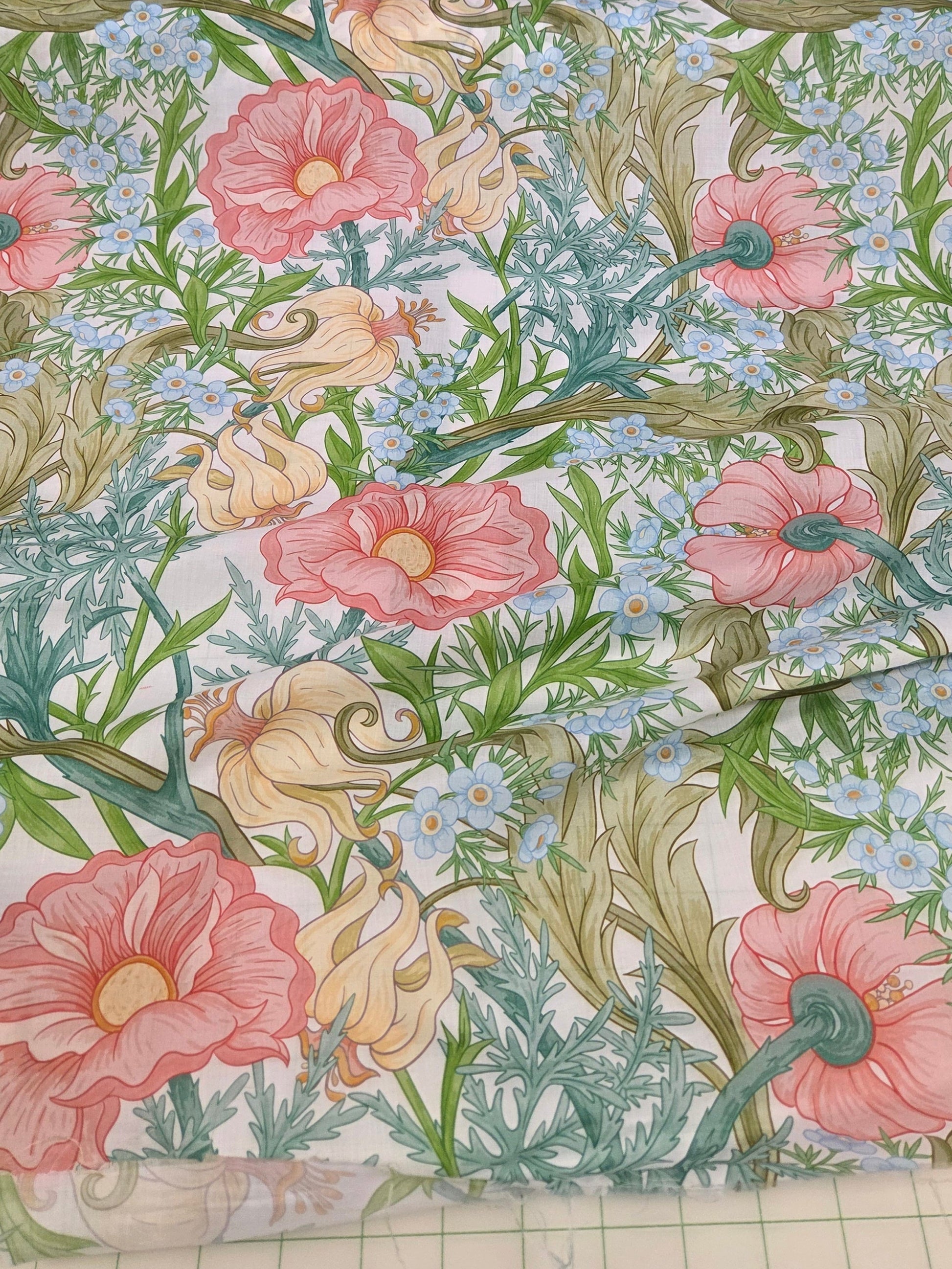 cotton linen vintage floral woven voile weight with pink, yellow and blue florals scattered on white ground.