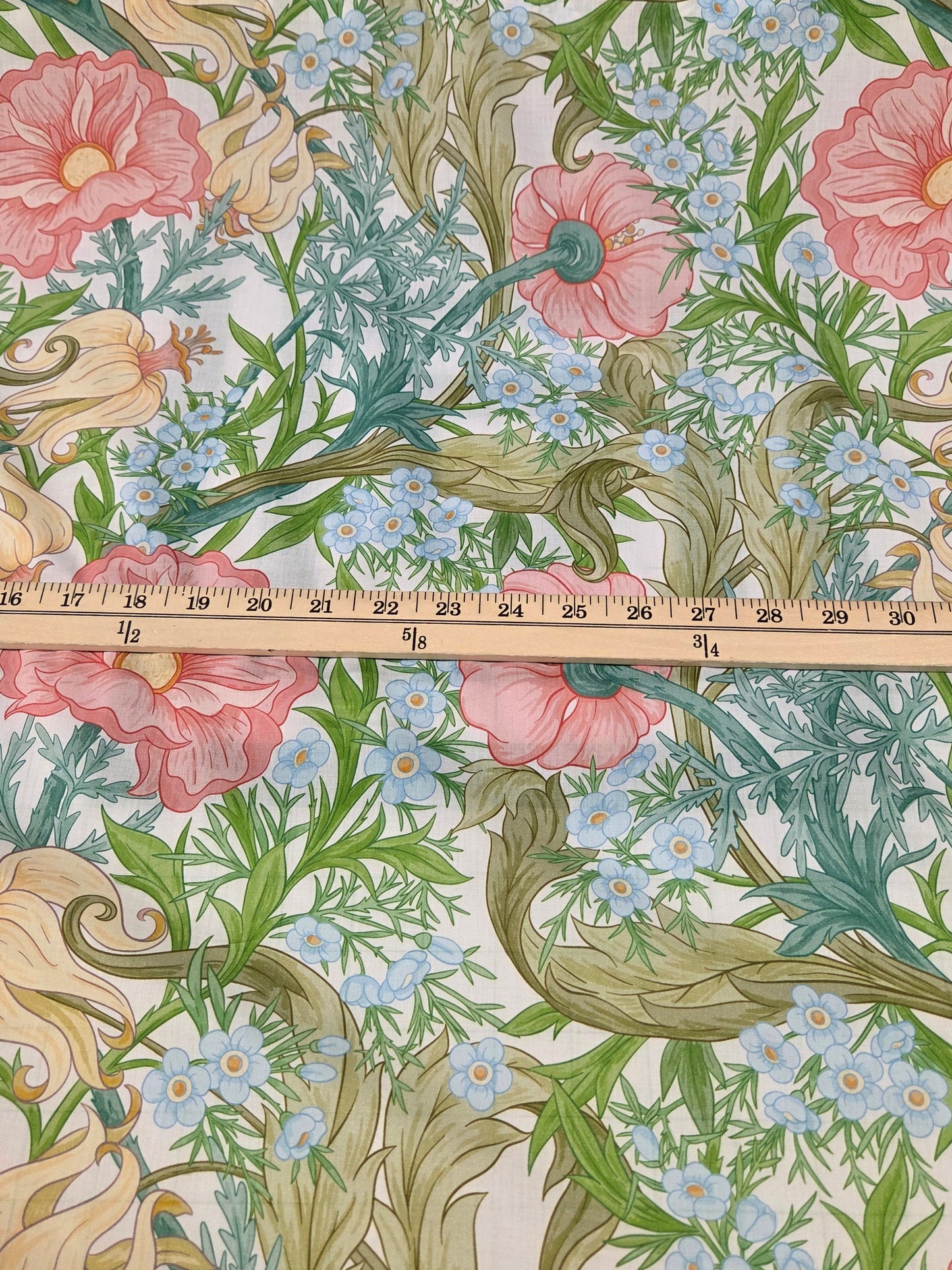Floral patterned fabric with a ruler for scale on a grid background