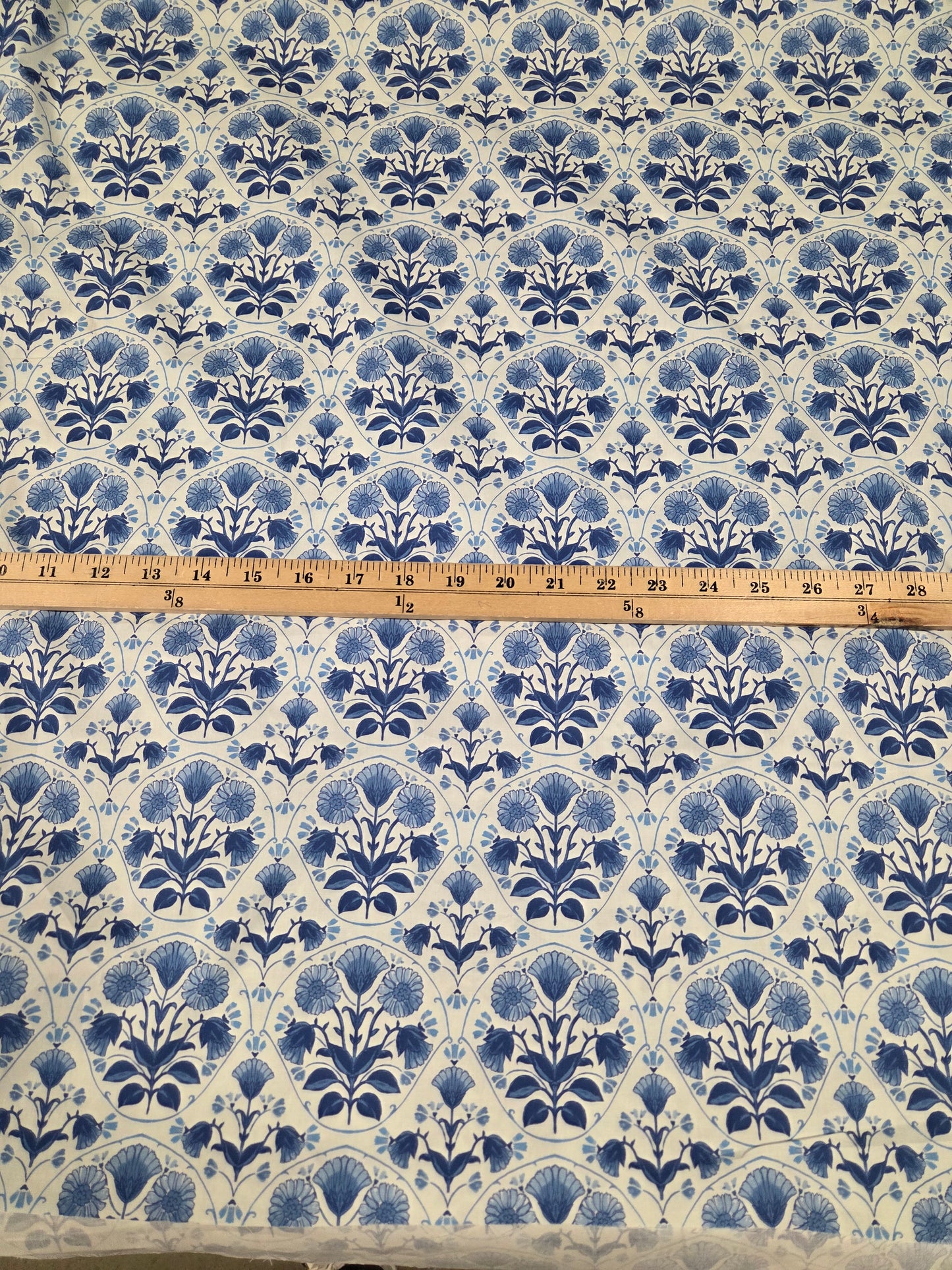 Fabric with blue floral pattern and a ruler for scale