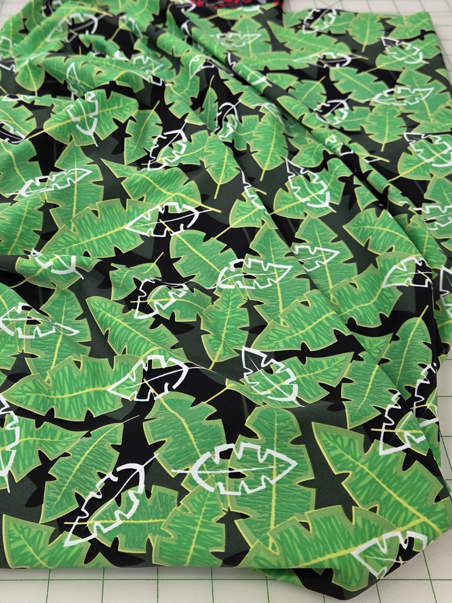 Fabric with green leaf pattern on a cutting mat