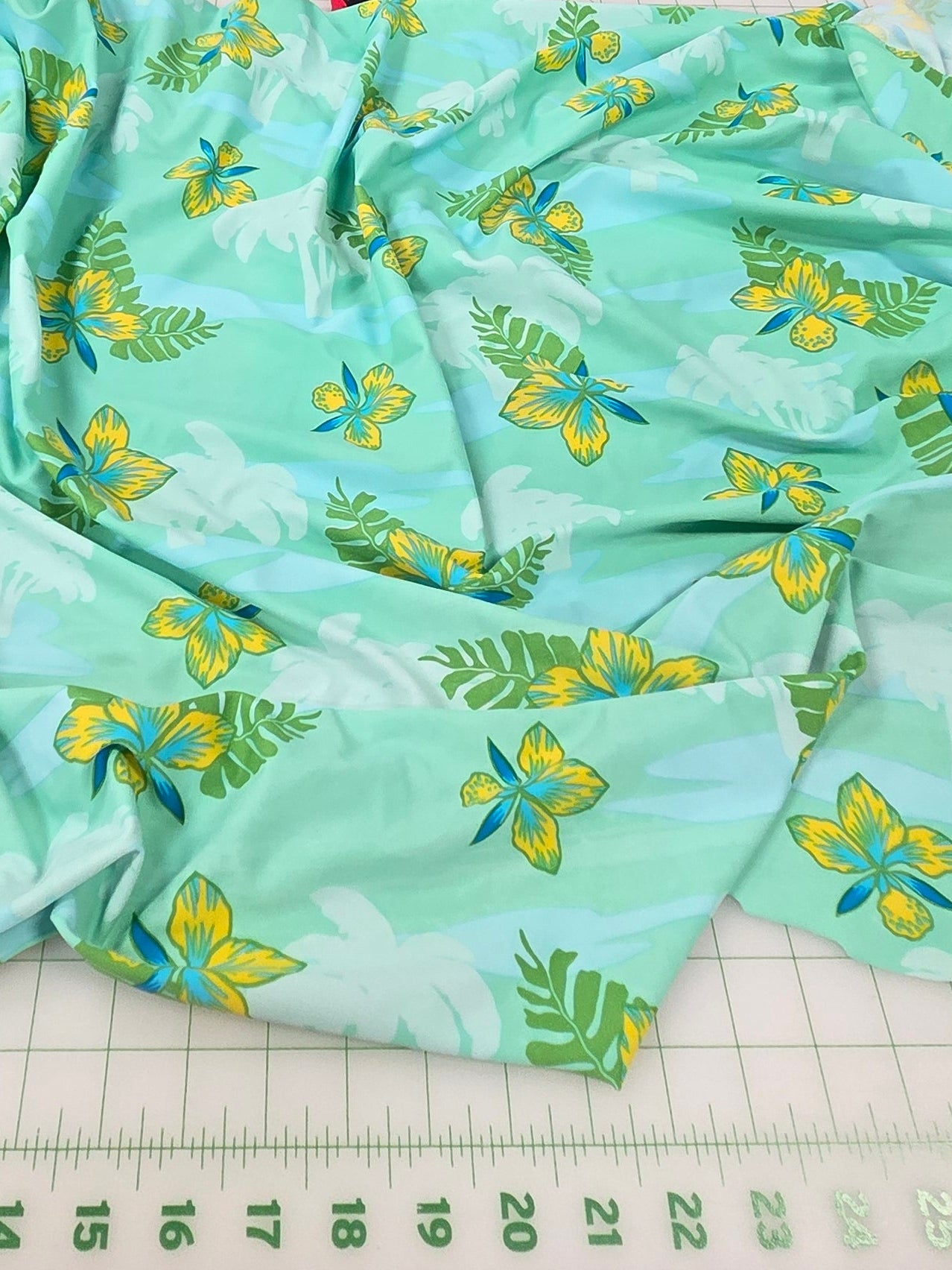 Green fabric with yellow patterns on a table in a store setting