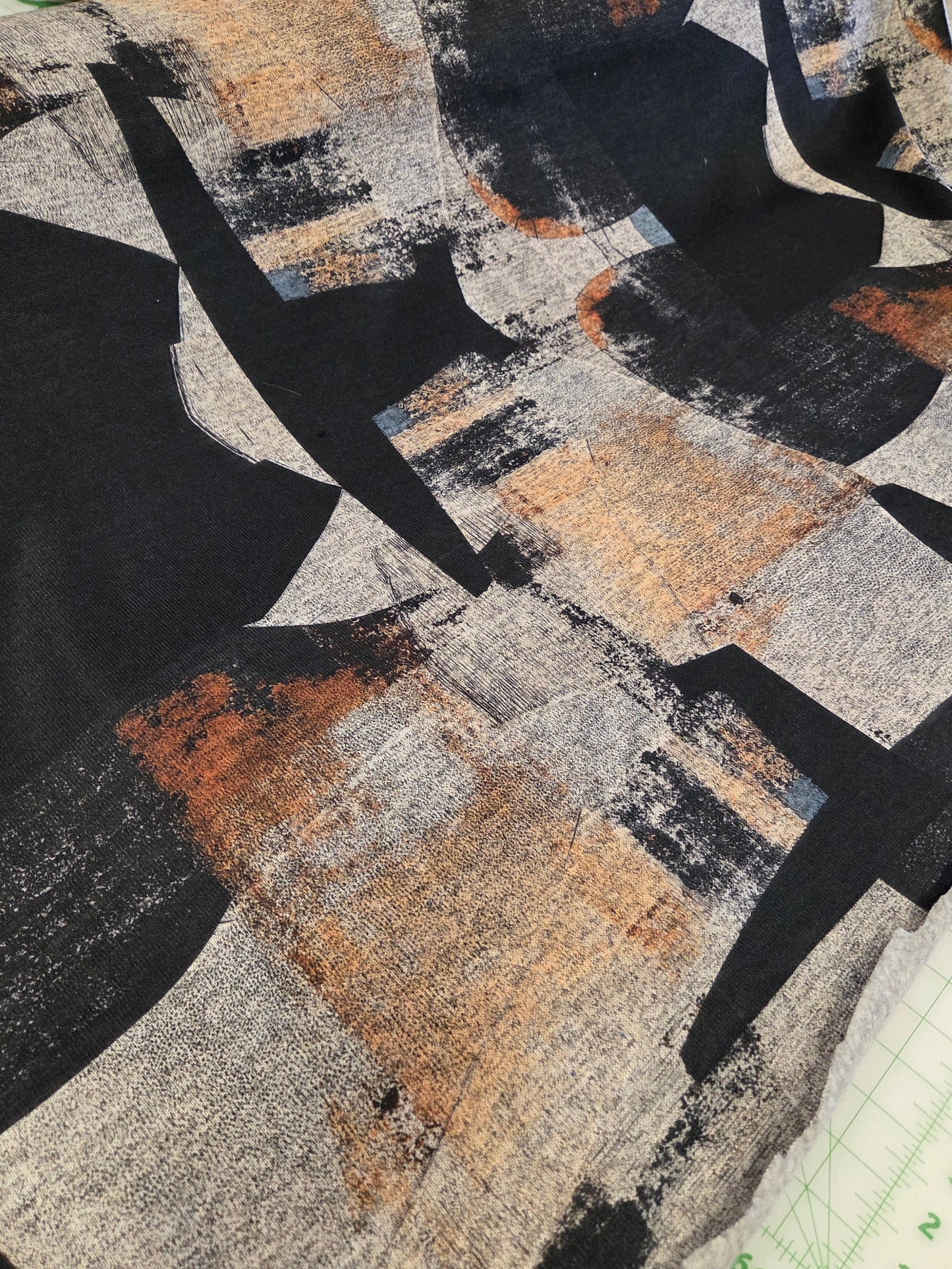 Textile sample with abstract pattern featuring black, gray, and brown colors.