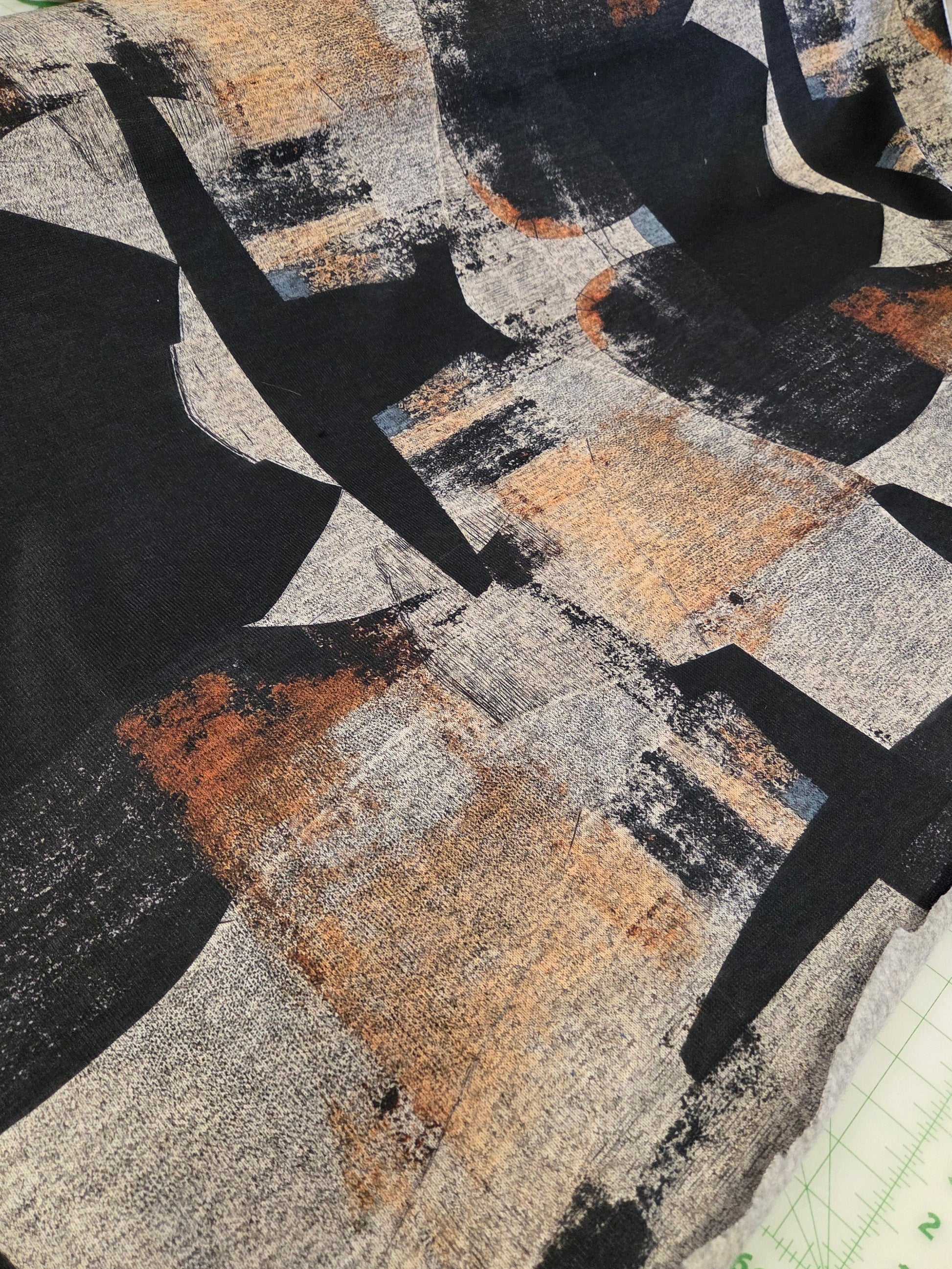 Textile sample with abstract pattern featuring black, gray, and brown colors.