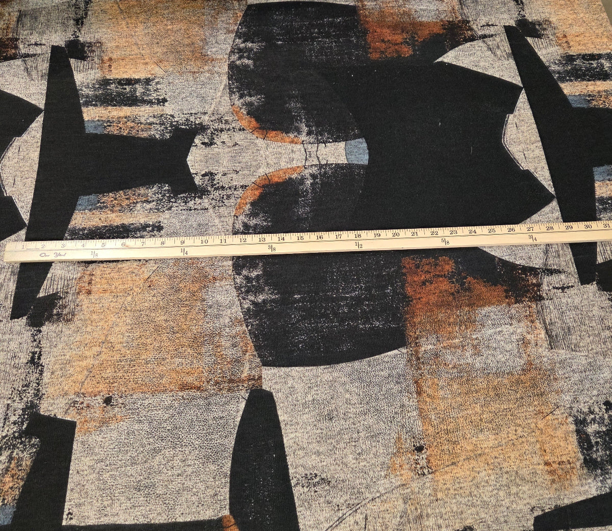 Abstract art piece with black, brown, and gray colors on a textured surface.