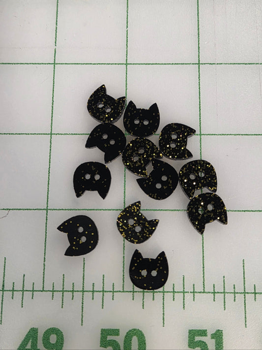 Black cat-shaped objects on a white surface with green grid lines and measurements.