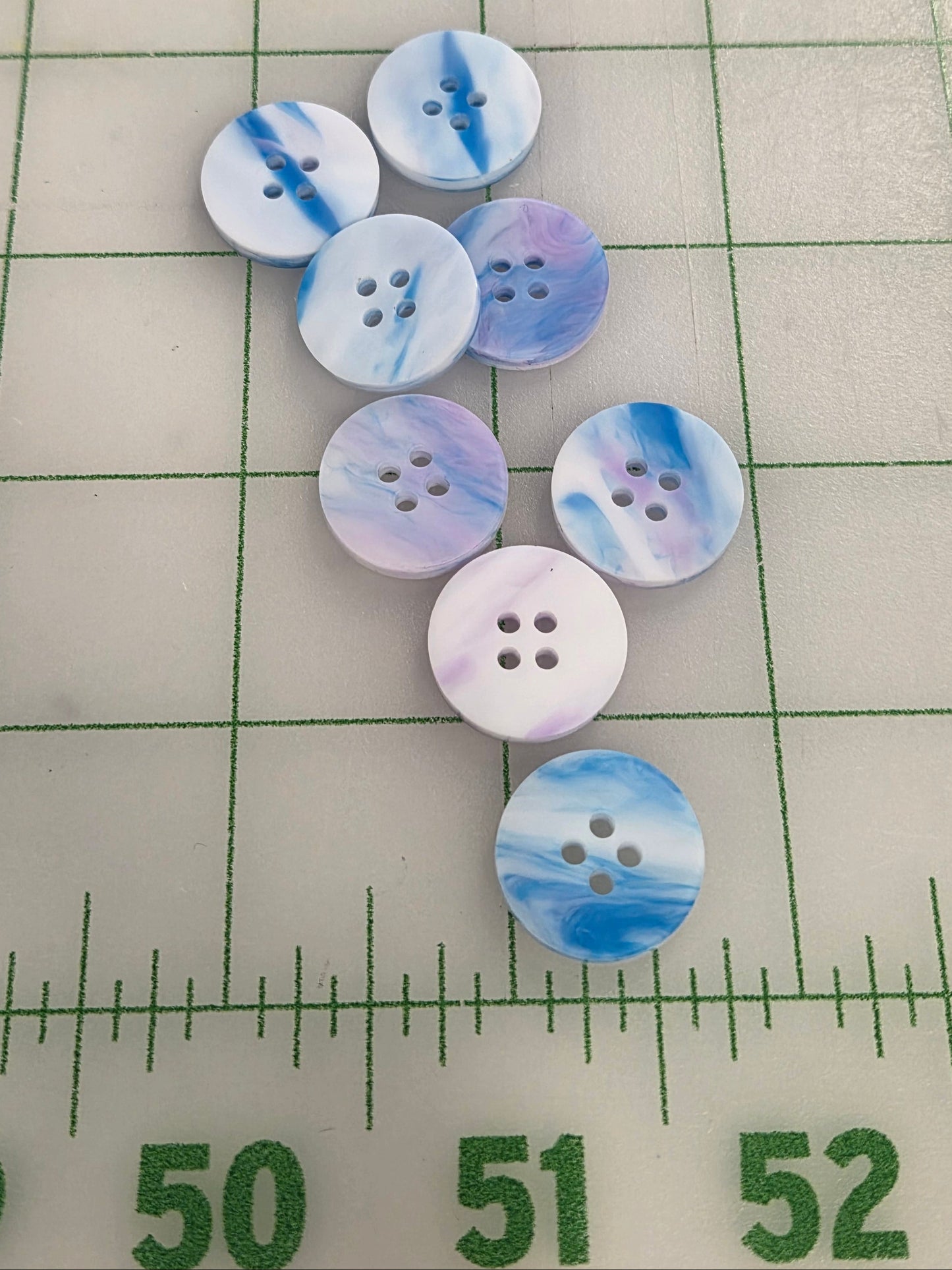 Set of buttons with watercolor design on a grid background with ruler