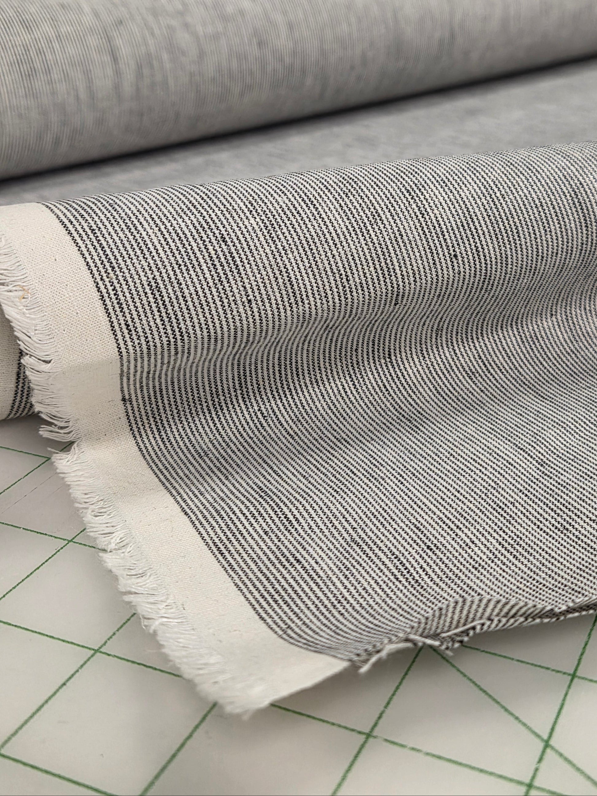 Textured fabric roll with fringe on a tiled floor